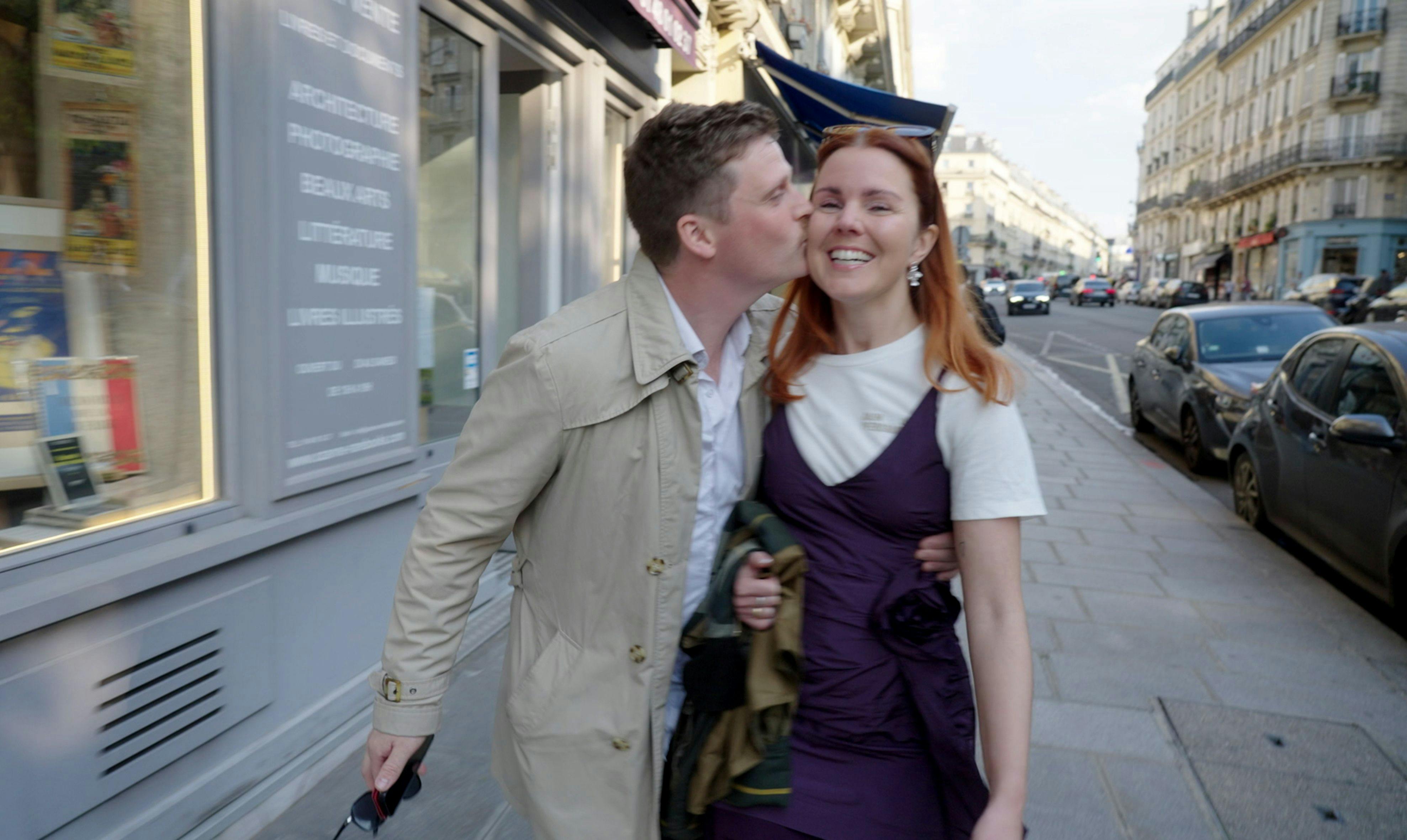 Et par, der står på gaden og kysser hinanden.