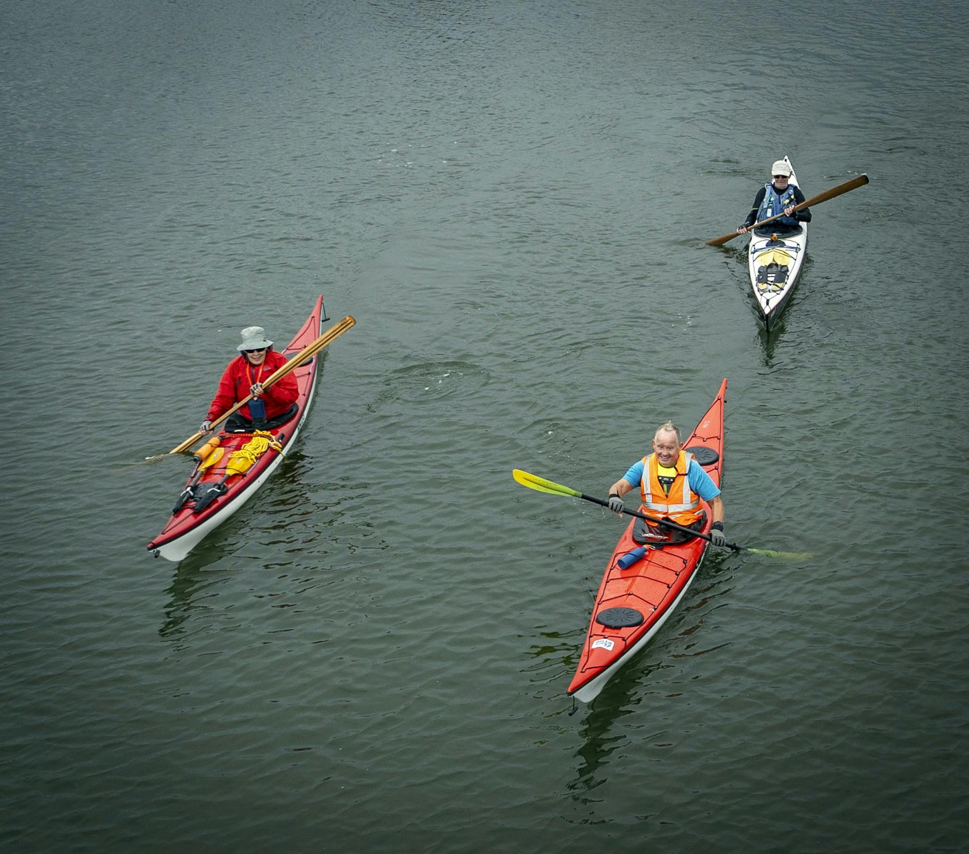 Blinde Sven Mogensen i kajak med to seende hjælpere roende omkring sig.