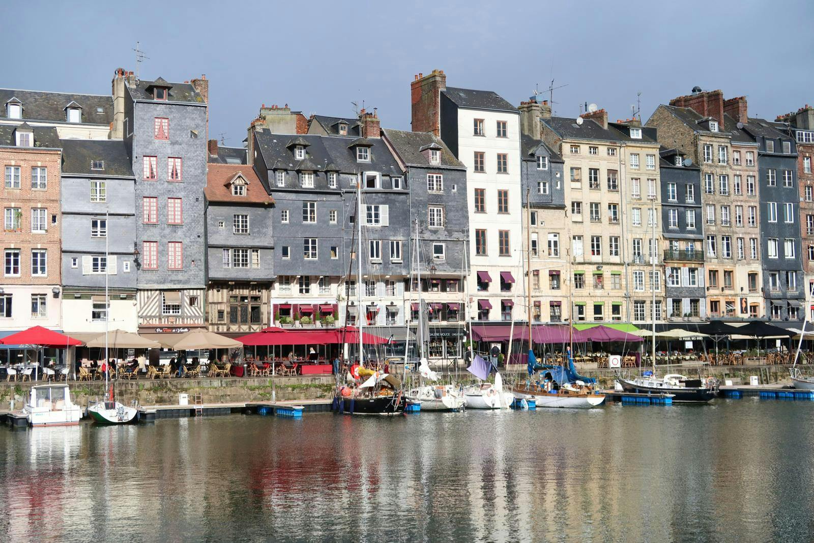 En havn i en by med pastelfarvede huse set fra vandsiden.