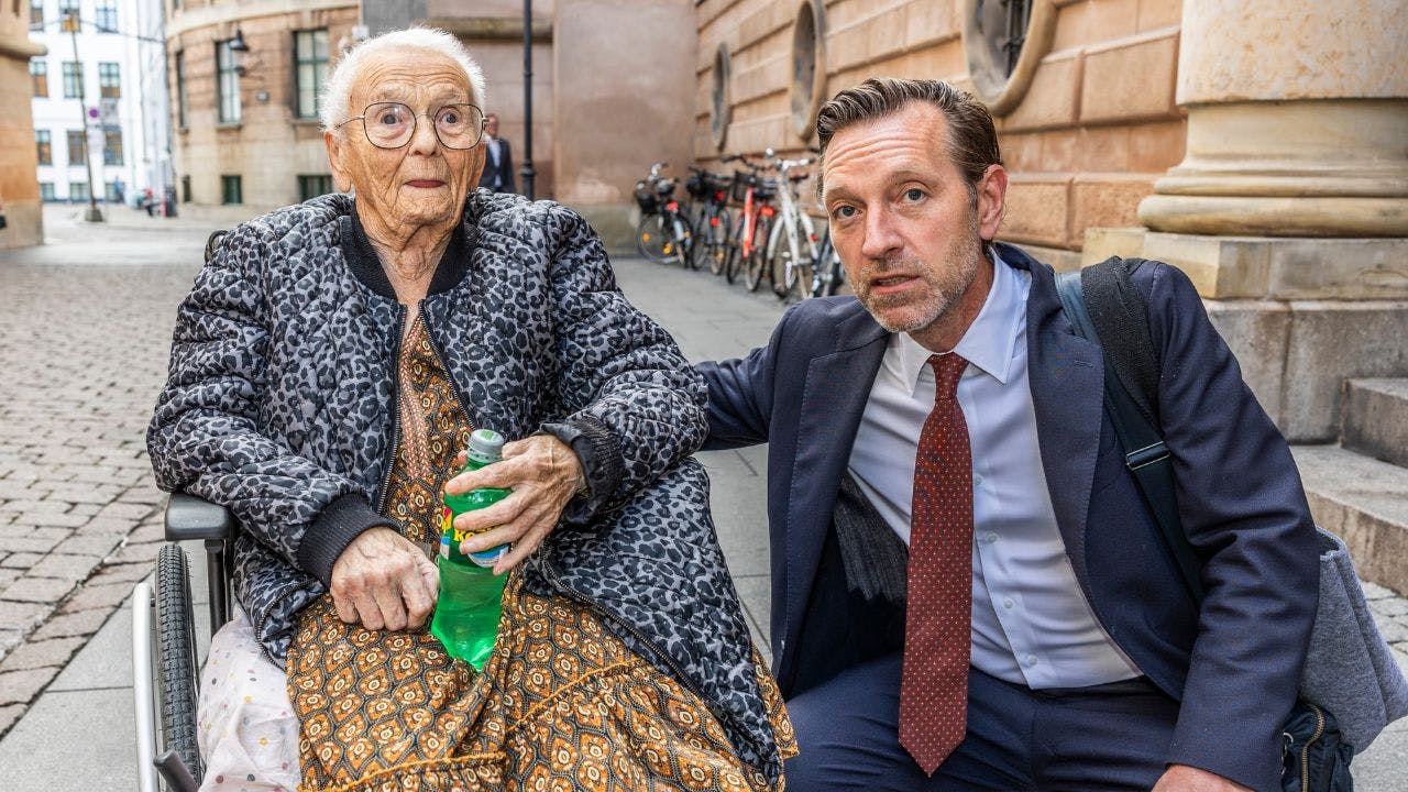 To ældre kvinde går ved siden af advokat foran byret