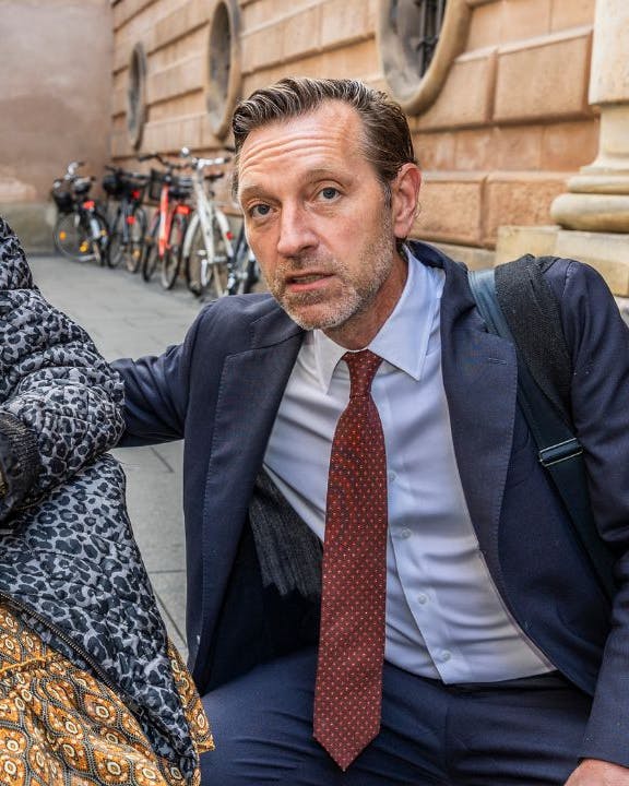 Ældre kvinde i kørestole ved siden af advokat iført jakkesæt
