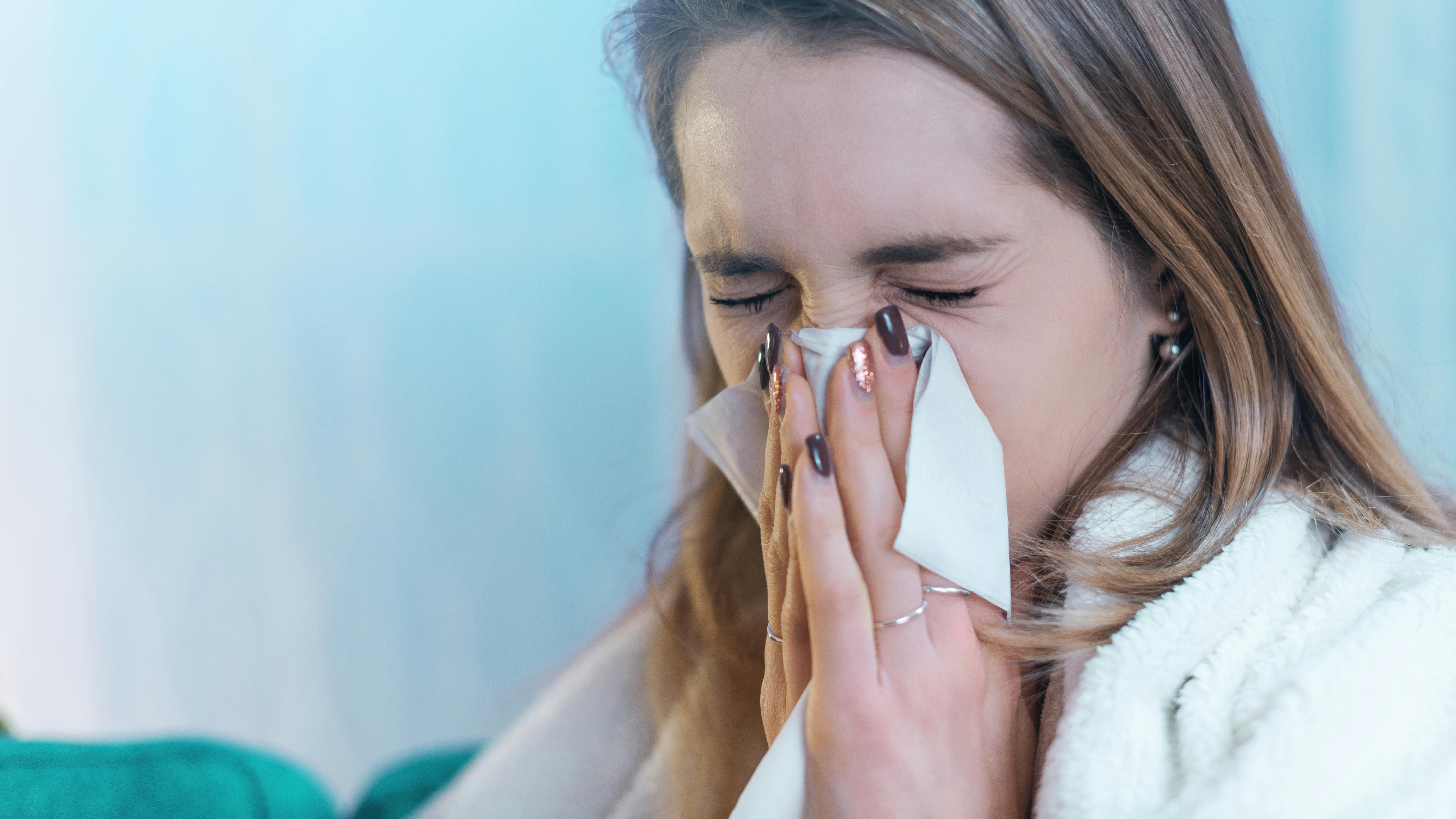 Ung kvinde pudser næse