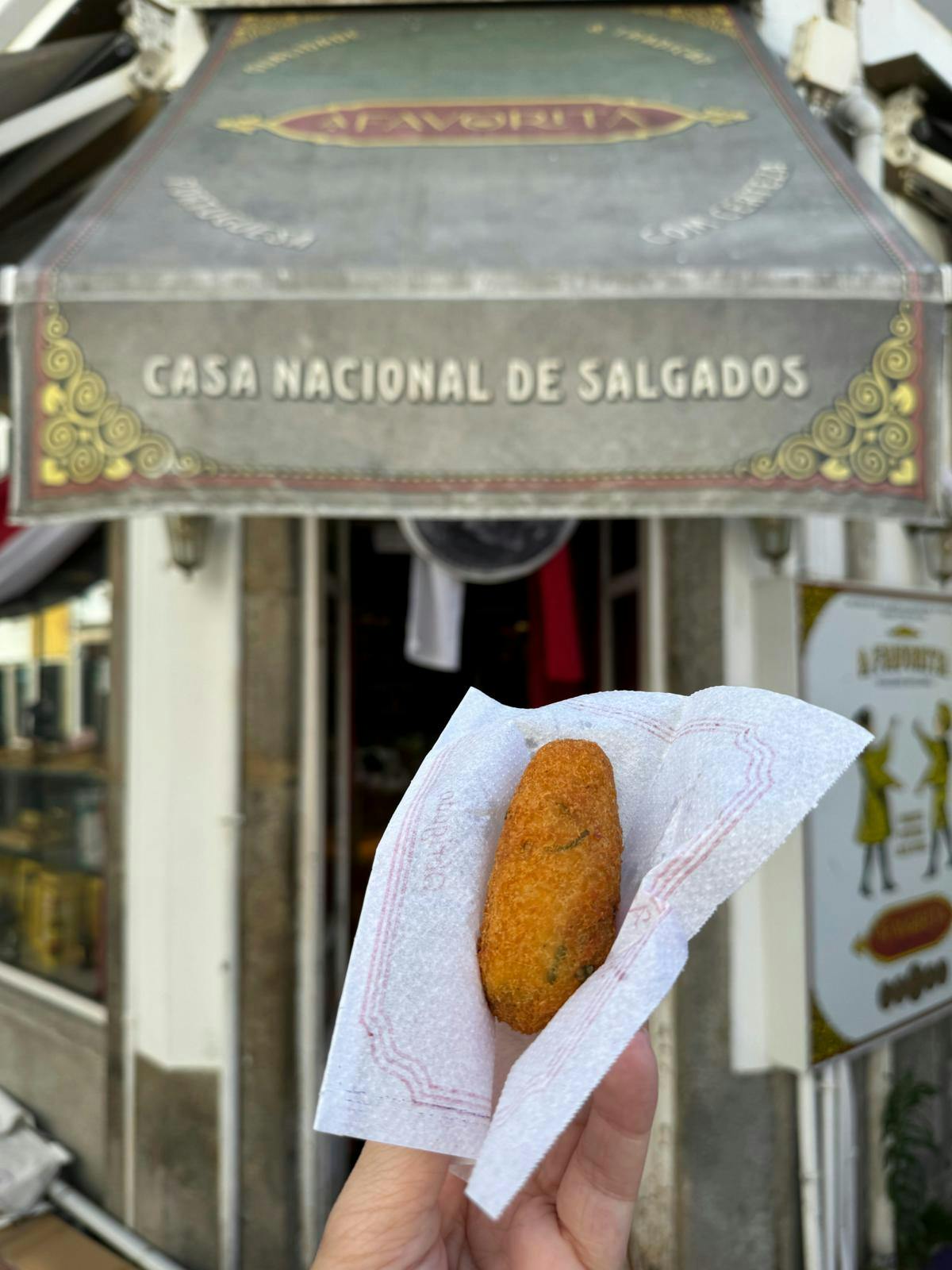 En hånd, der holder om en hvid serviet med bacalhau.