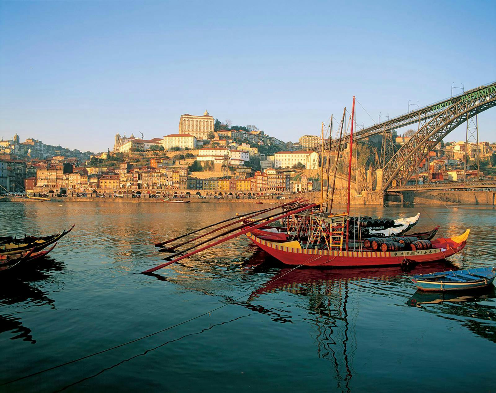 En gammeldags sejlbåd, der ligger i vandet tæt på en kyst i Portugal