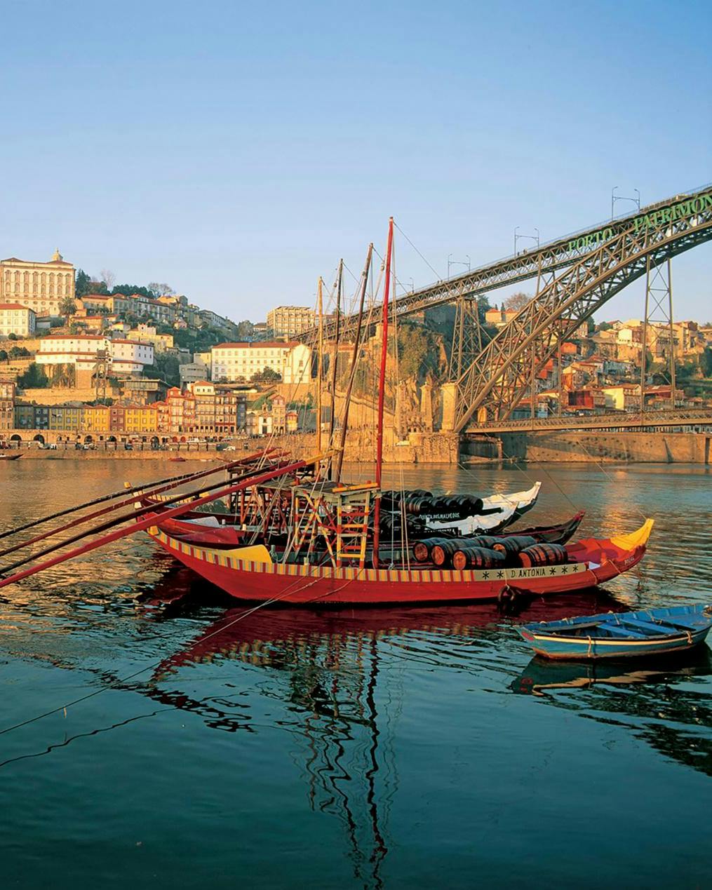 En gammeldags sejlbåd, der ligger i vandet tæt på en kyst i Portugal