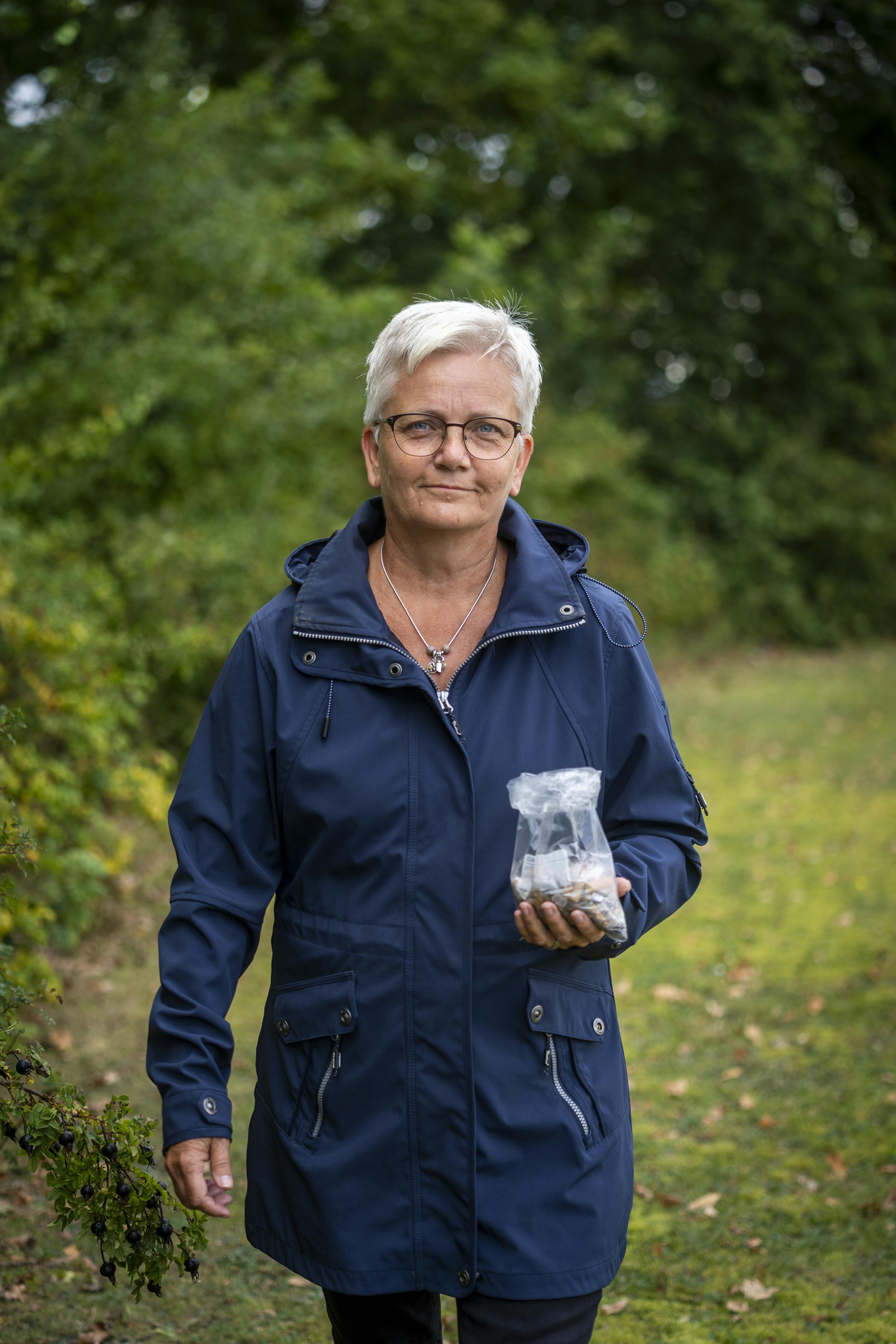 Henriette Weibel samler cigaretskodder i en pose.
