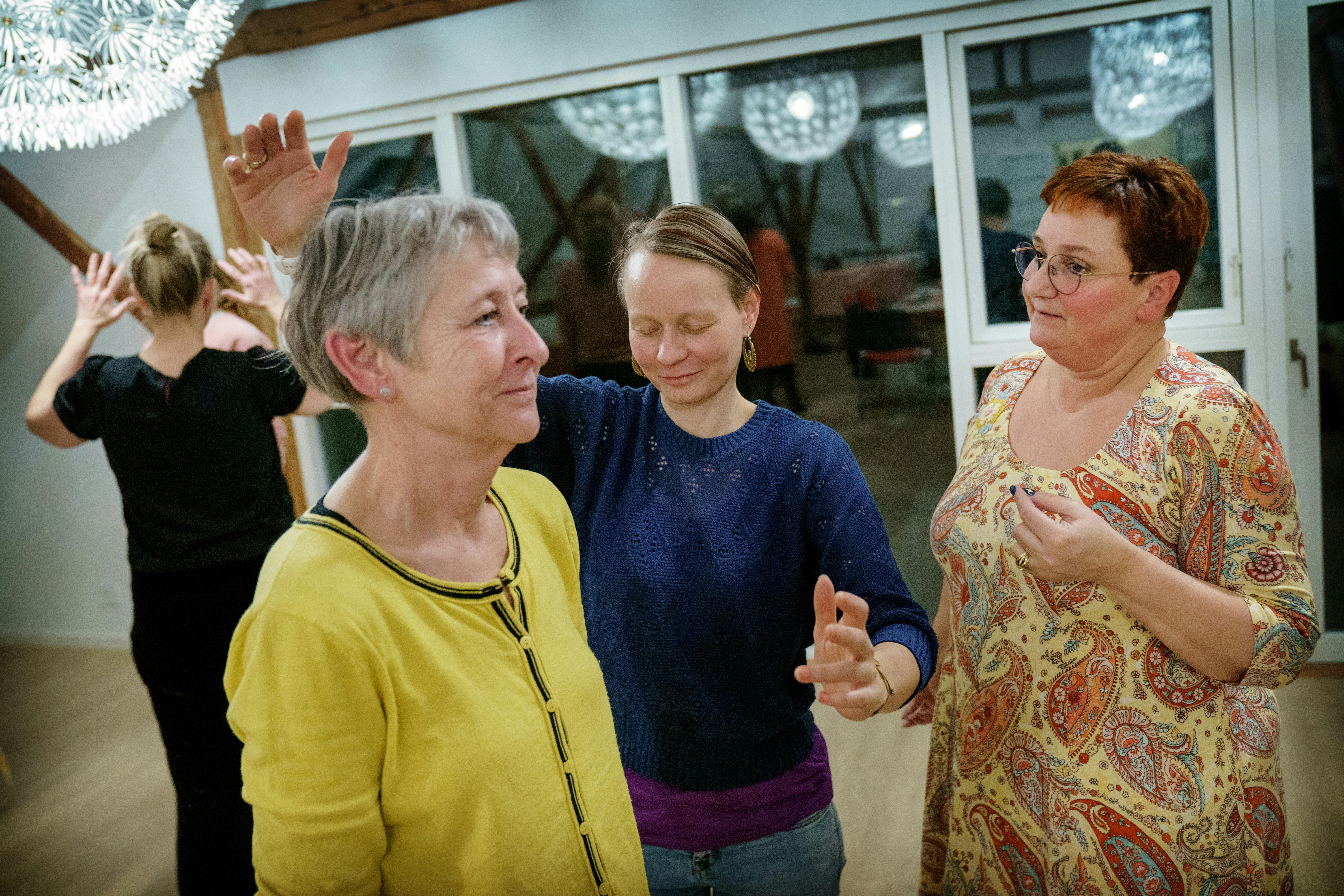 Kvinder står i rum og bevæger armene