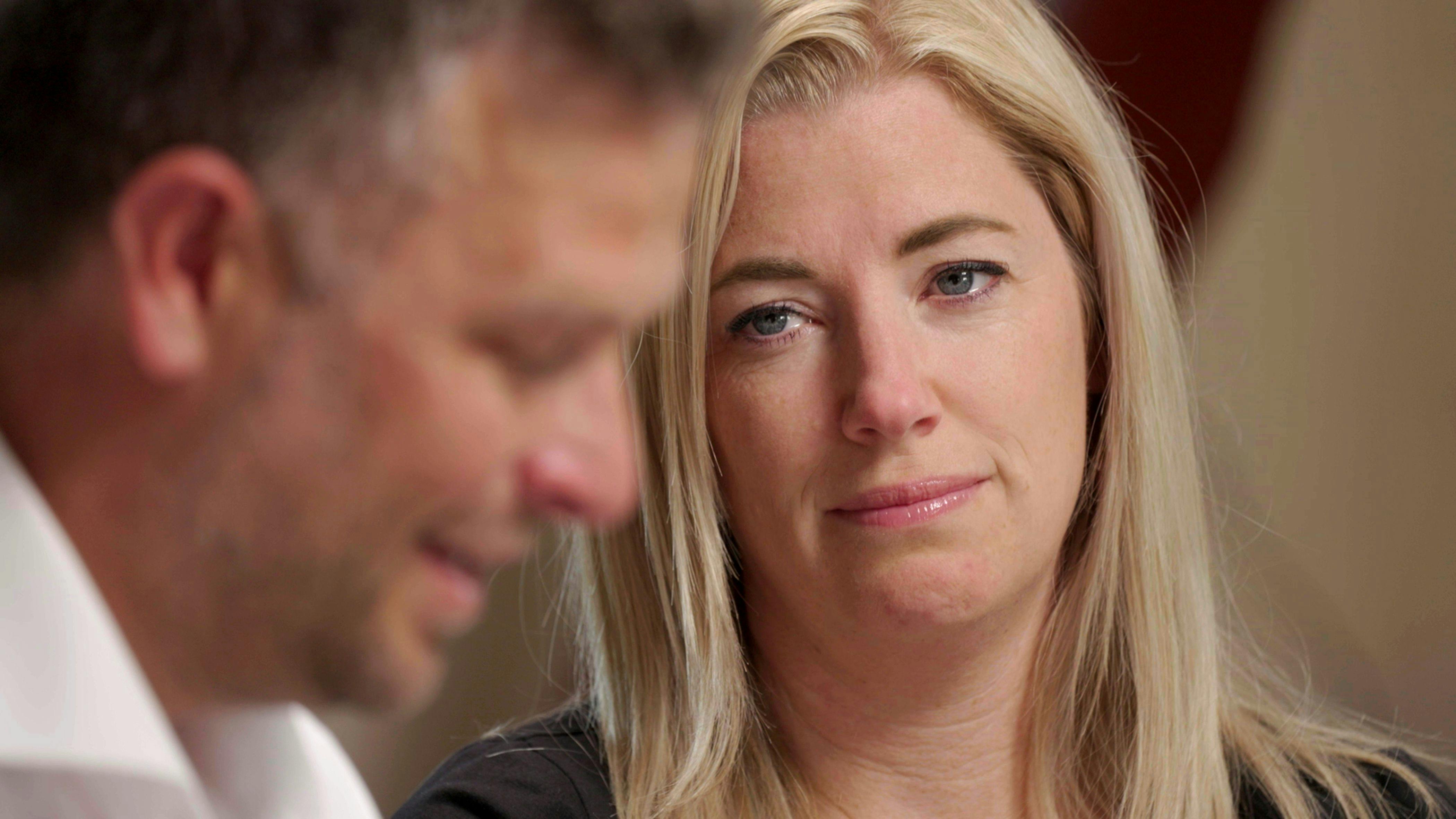 En kvinde med tårer i øjnene, der kigger en mand, som også ser lidt trist ud.