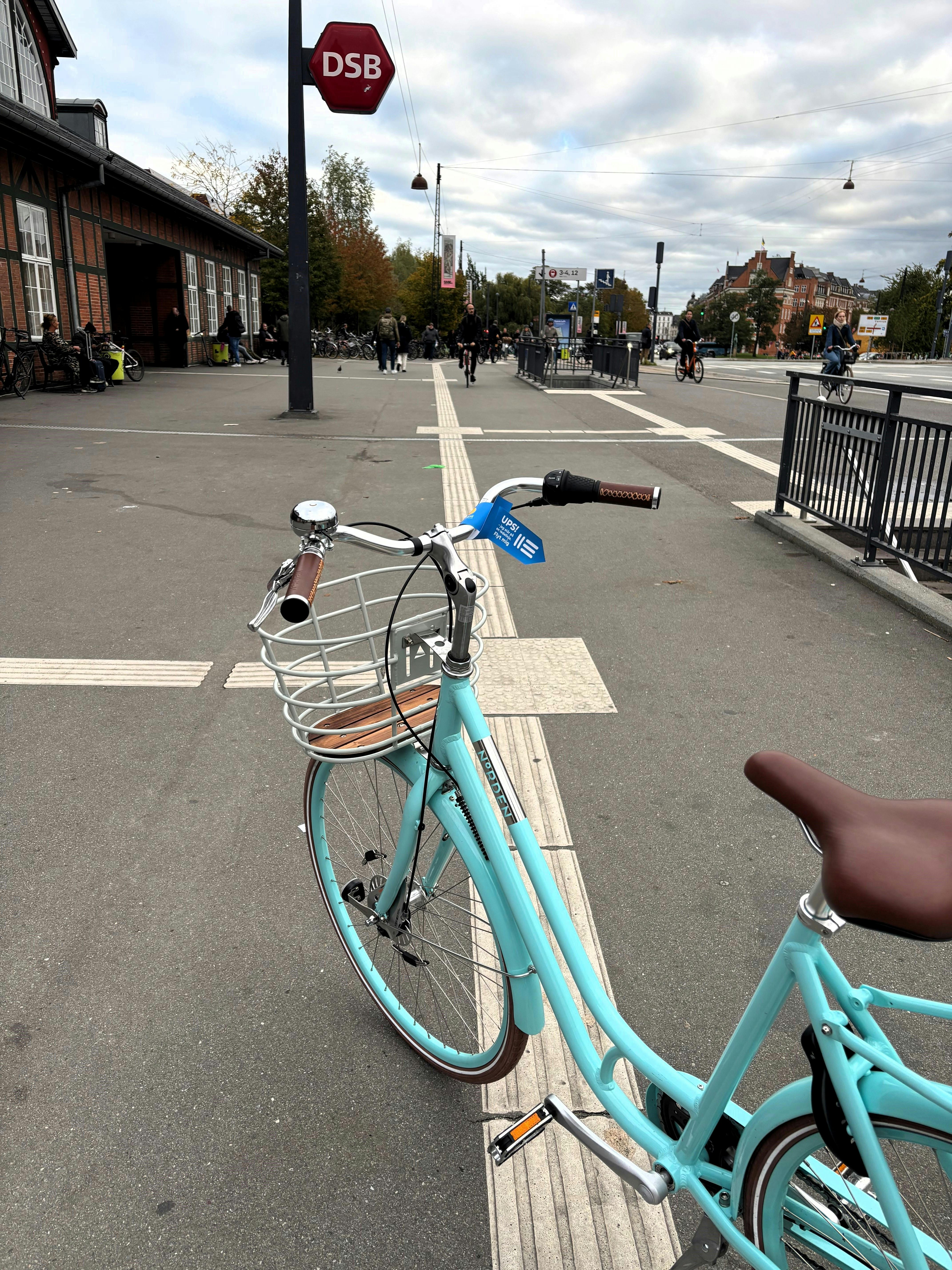Cykel, der er parkeret på en ledelinje på en station og har et blåt mærkat på styret