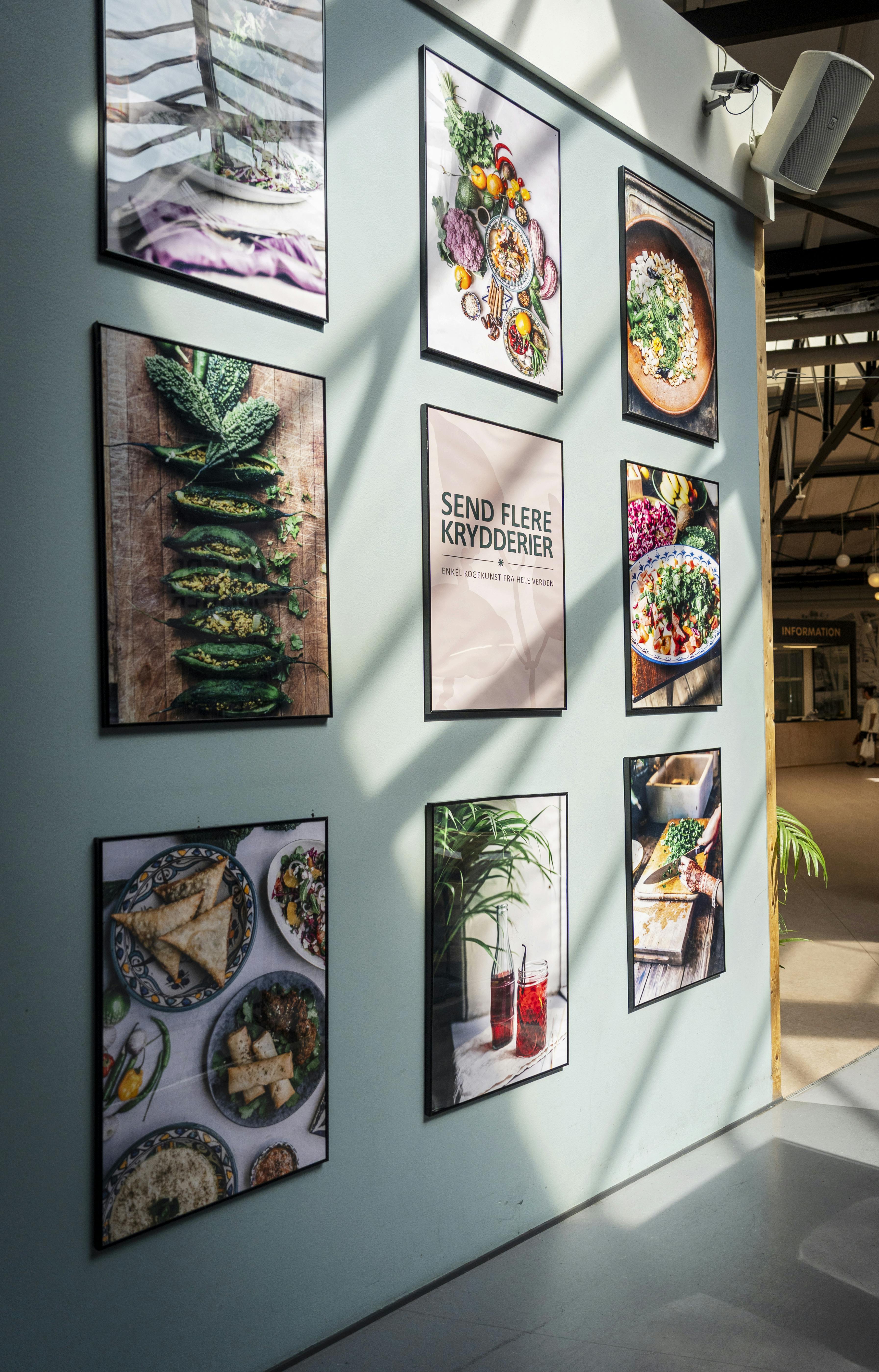 Madbilleder på væggen i caféen Send flere krydderier i Nørrebrohallen.