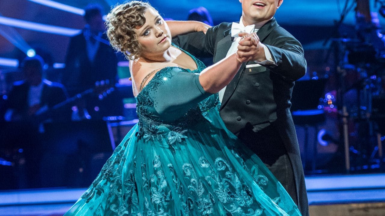 Kvinde danser stor kjole og kigger intenst ud i horisonten