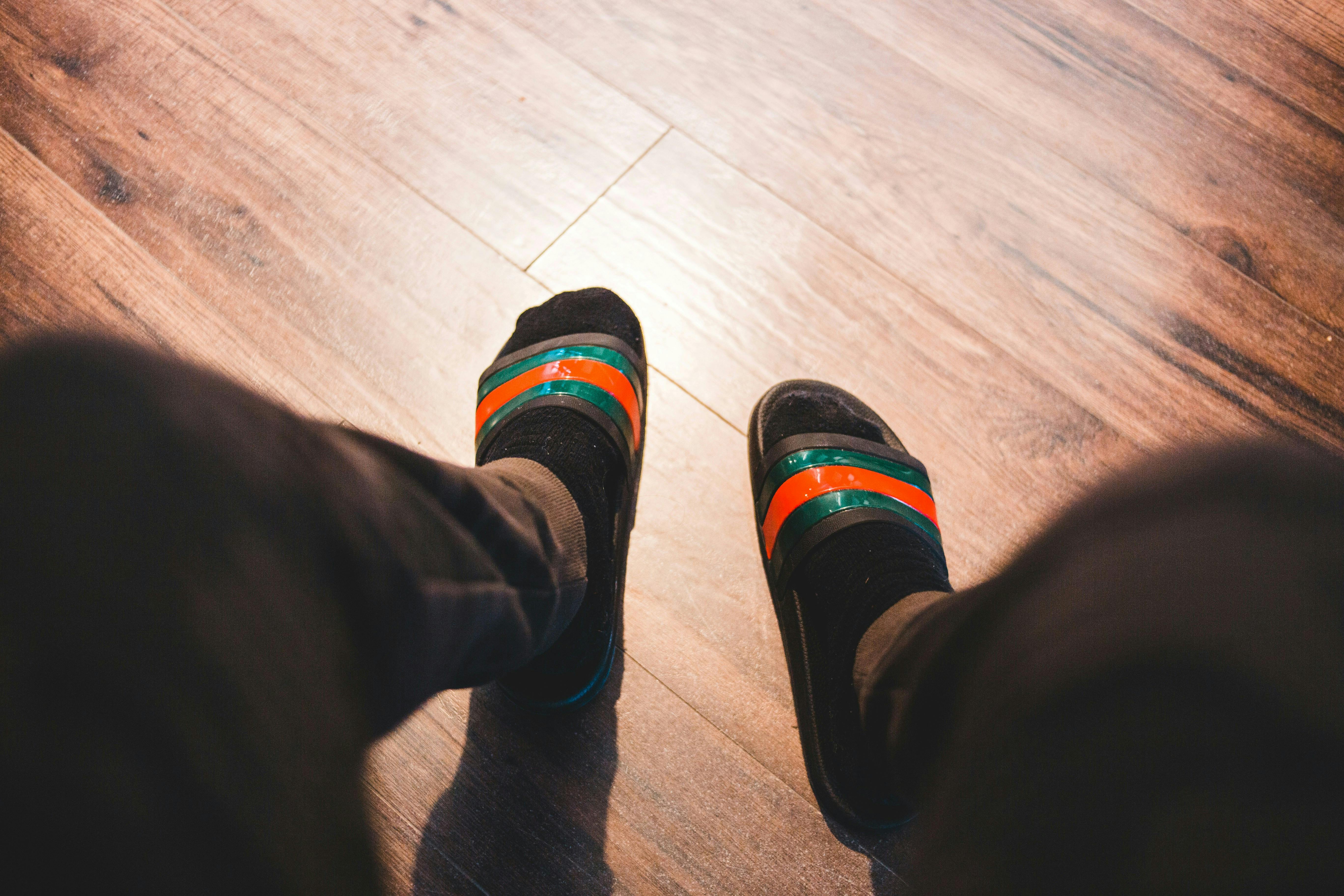 Et par ben med mørke bukser, strømper og klip-klappere