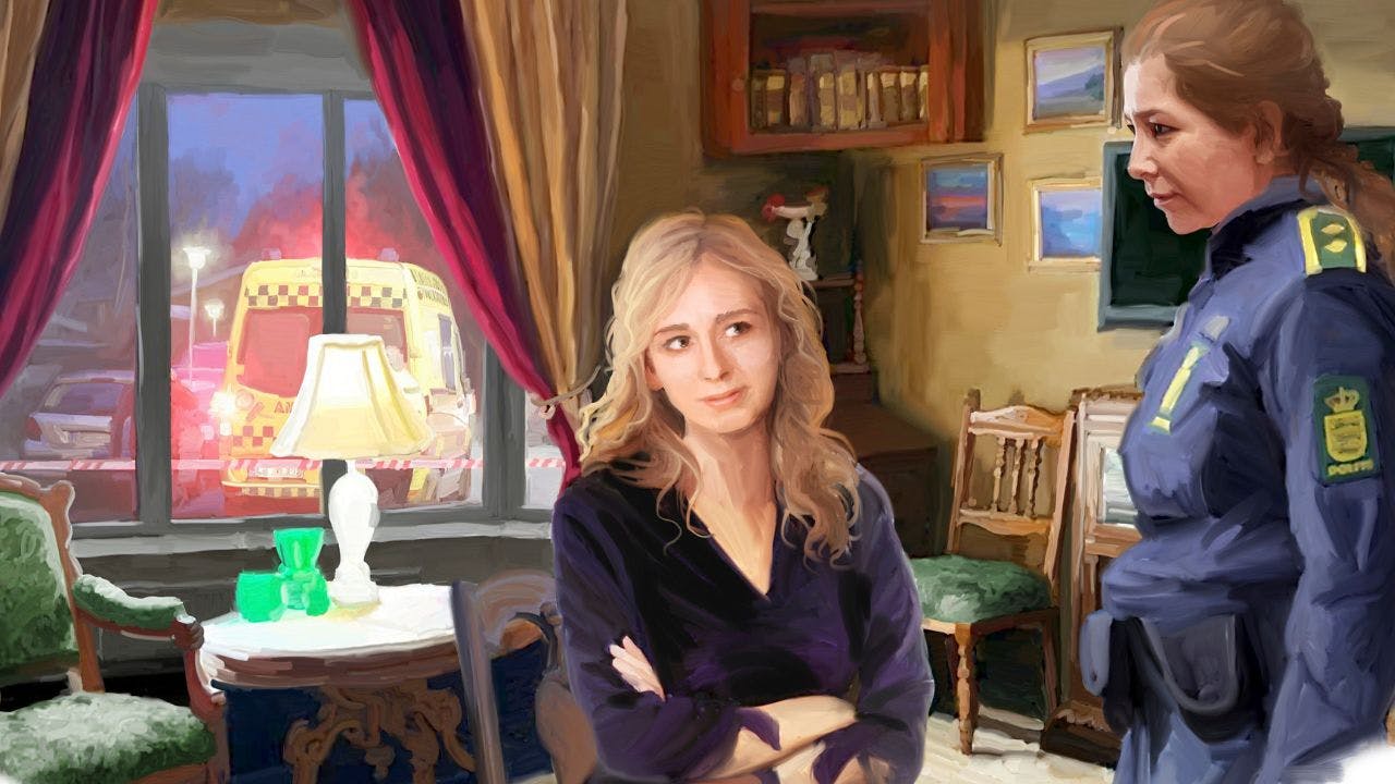 En kvinde sidder på en stol i heksekostumet og taler med en politikvinde i uniform, som står op