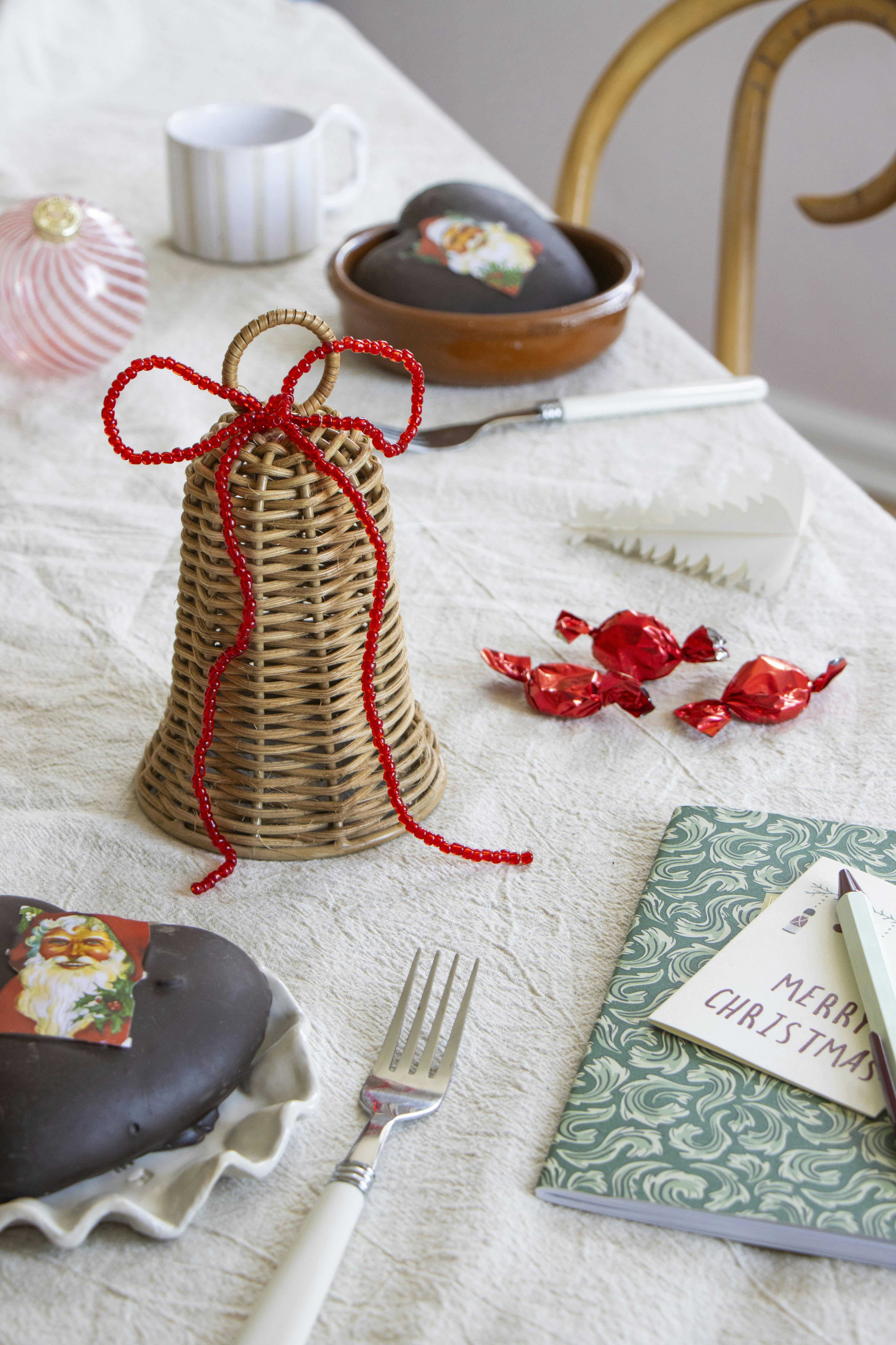 Rød sløjfe af perler bundet om en flettet klokke