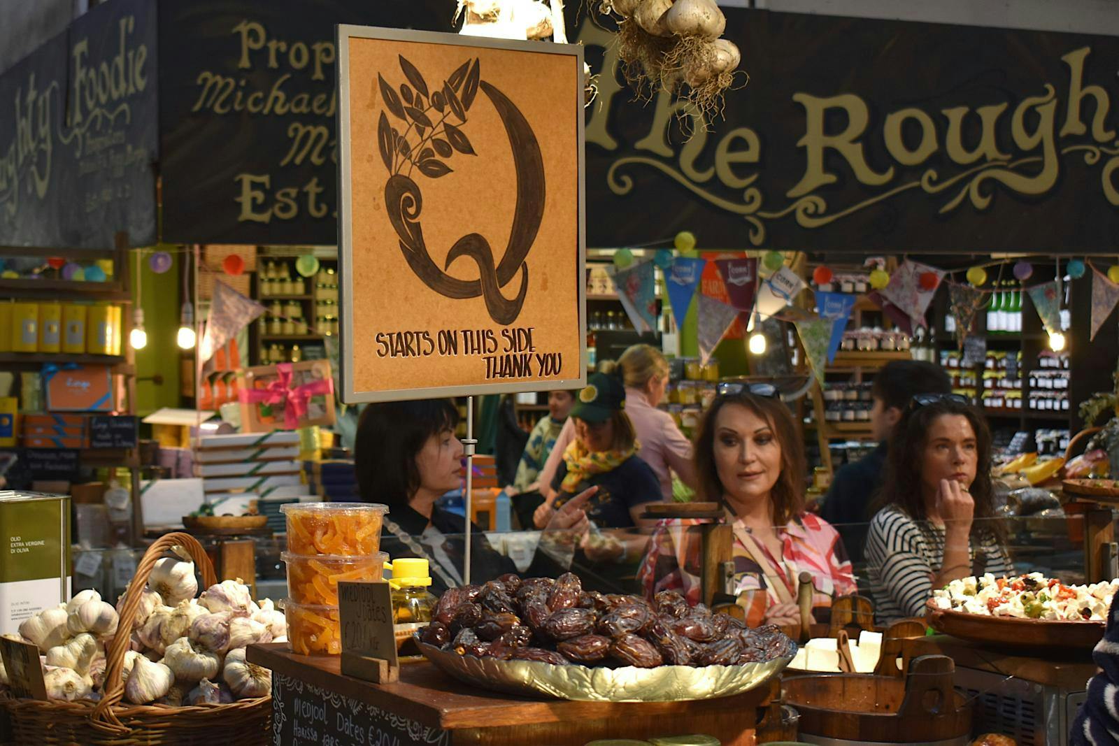 En masse madboder med besøgende, der kigger på lækkerierne.