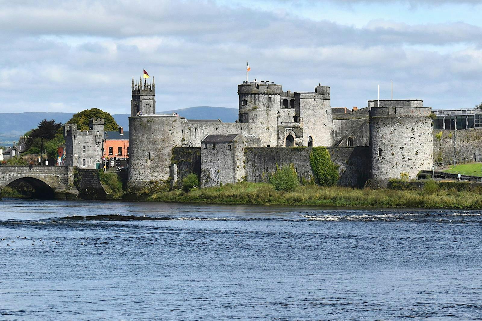 En stor, gammel borg ved siden af en flod.