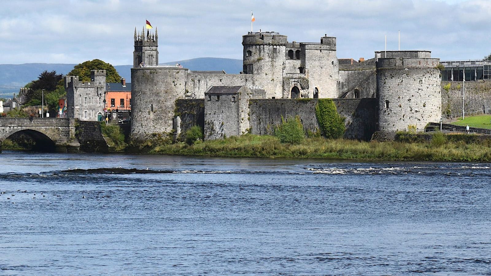 En stor, gammel borg ved siden af en flod.