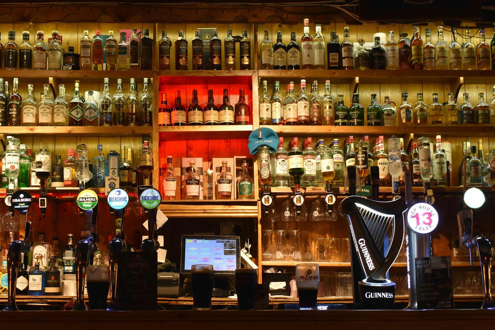 En bar fyldt med flasker og fadølsanker.