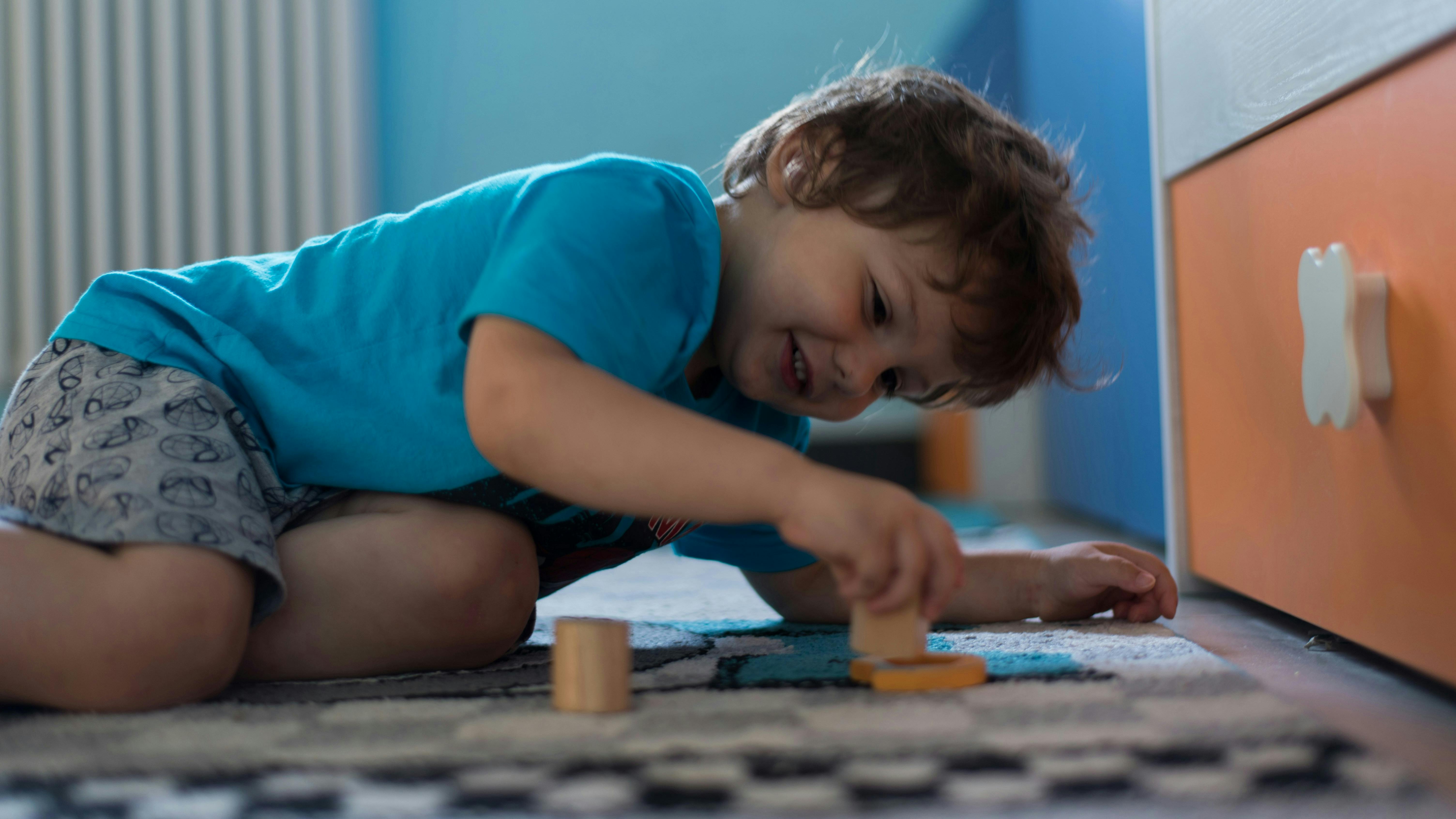 En dreng, der ligger på gulvet og leger