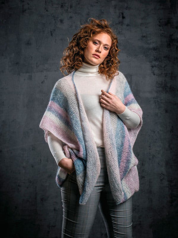 Kvinde med poncho i pastelfarver