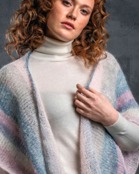 Kvinde med poncho i pastelfarver