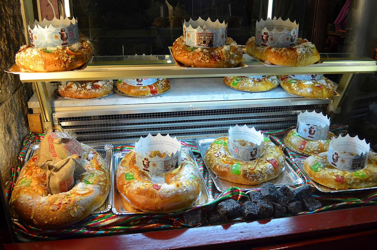 En glasmontre med store runde kager i.