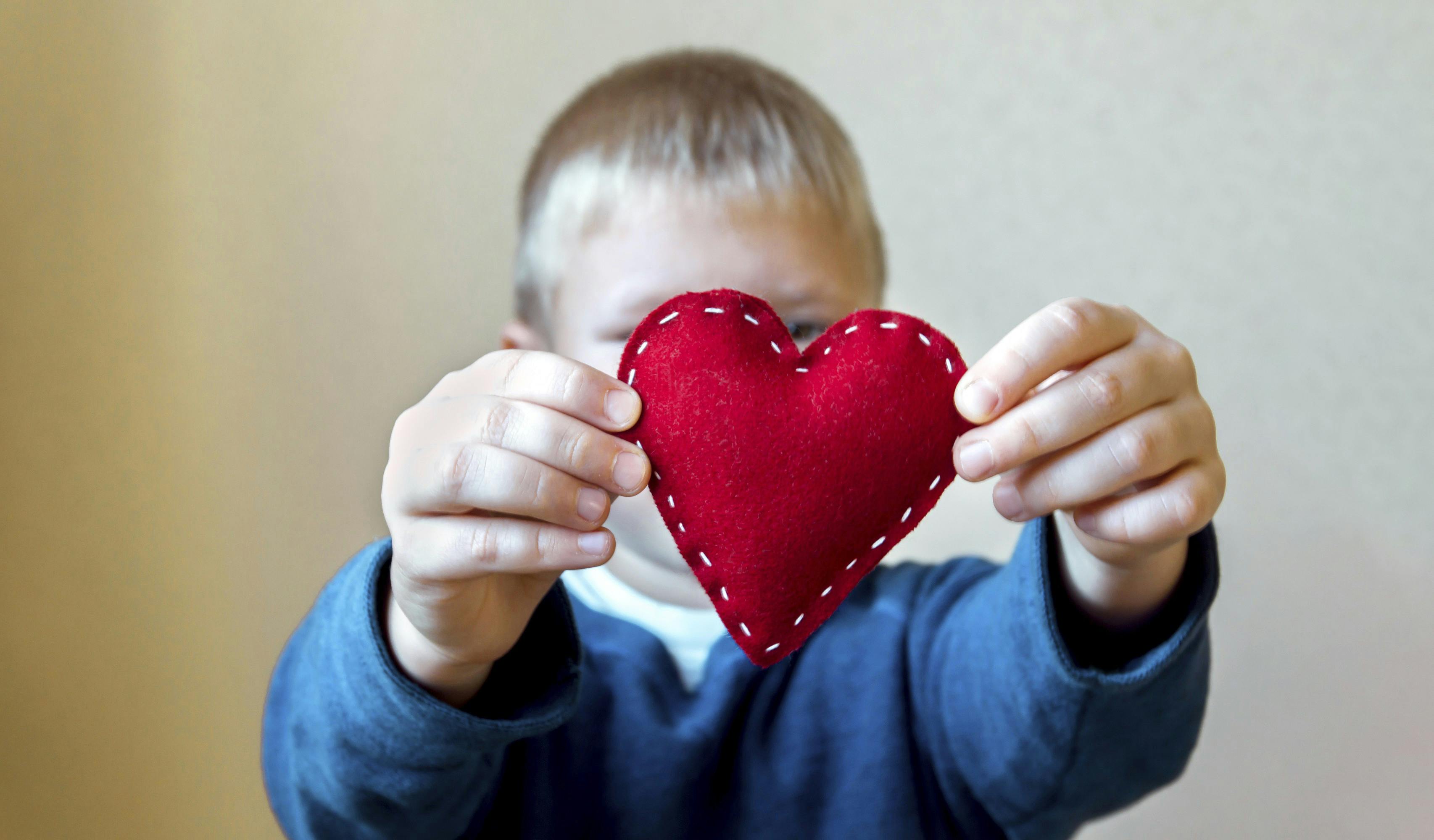 Dreng holder et rødt hjerte 