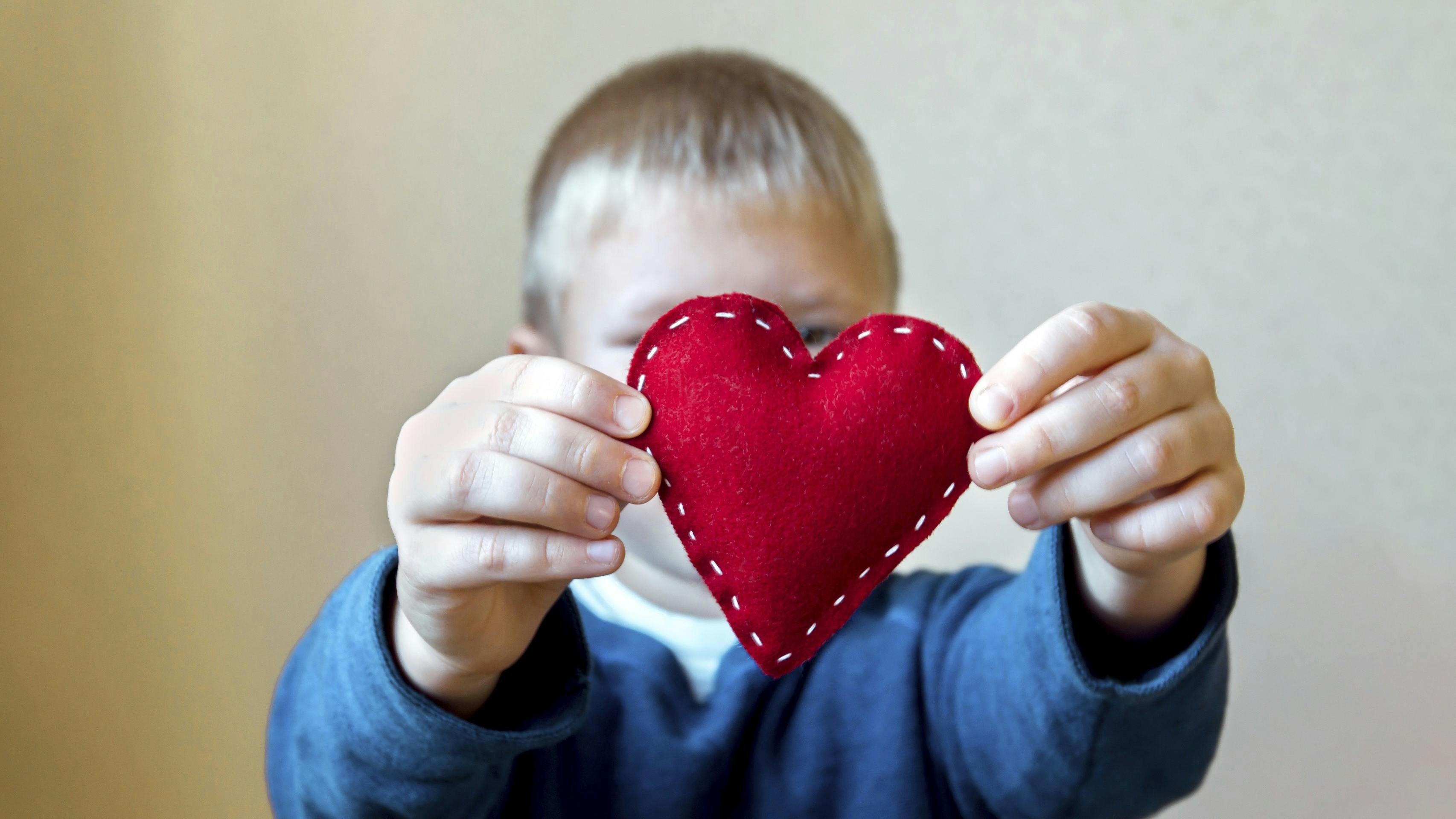 Dreng holder et rødt hjerte