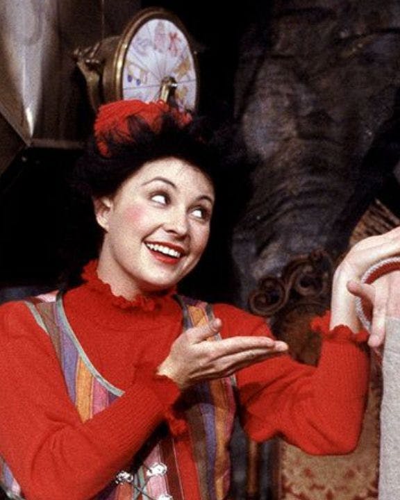 To nisser smiler og står med en sæk med gaver