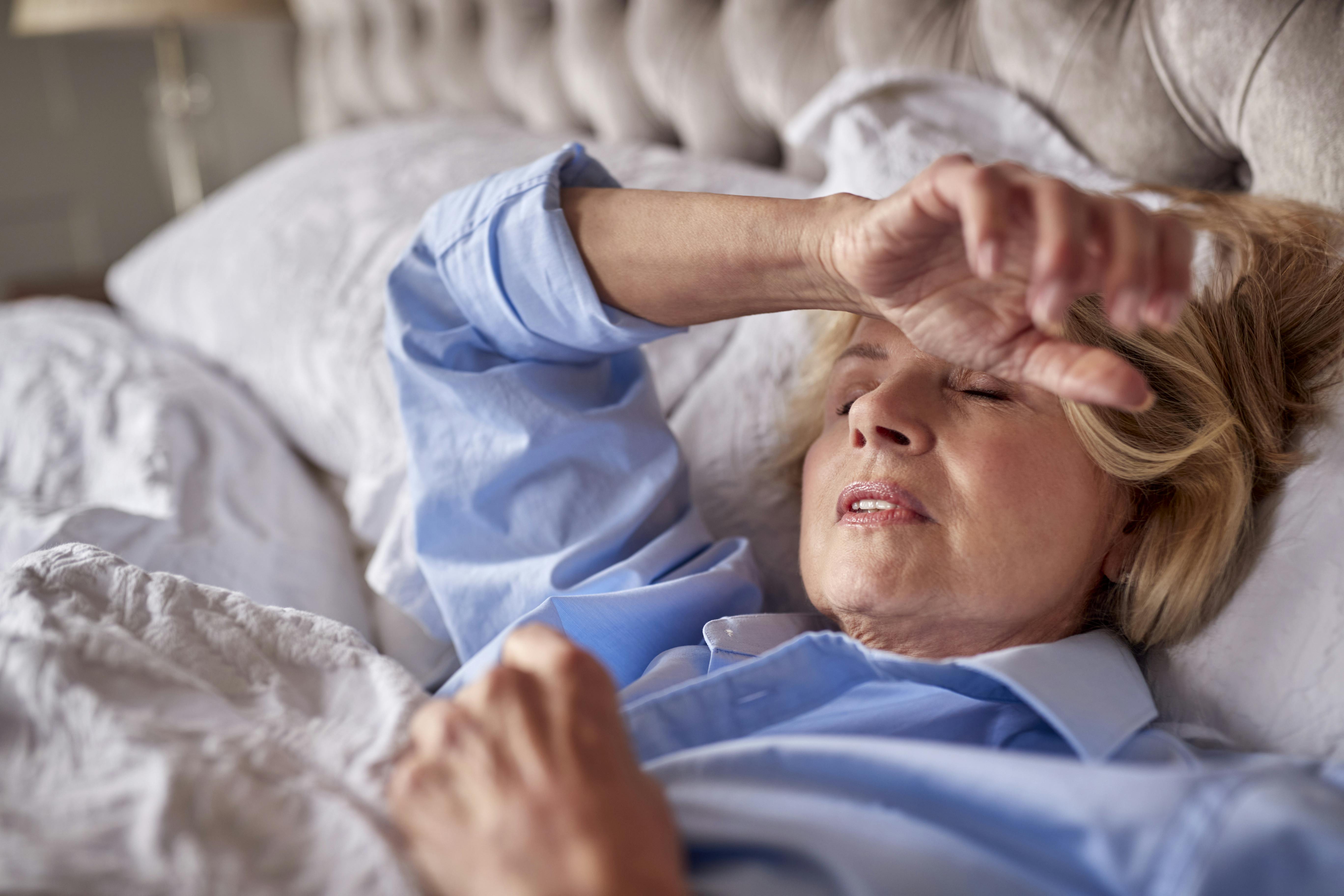 Kvinde i overgangsalderen kæmper med søvnbesvær derhjemme i sin seng