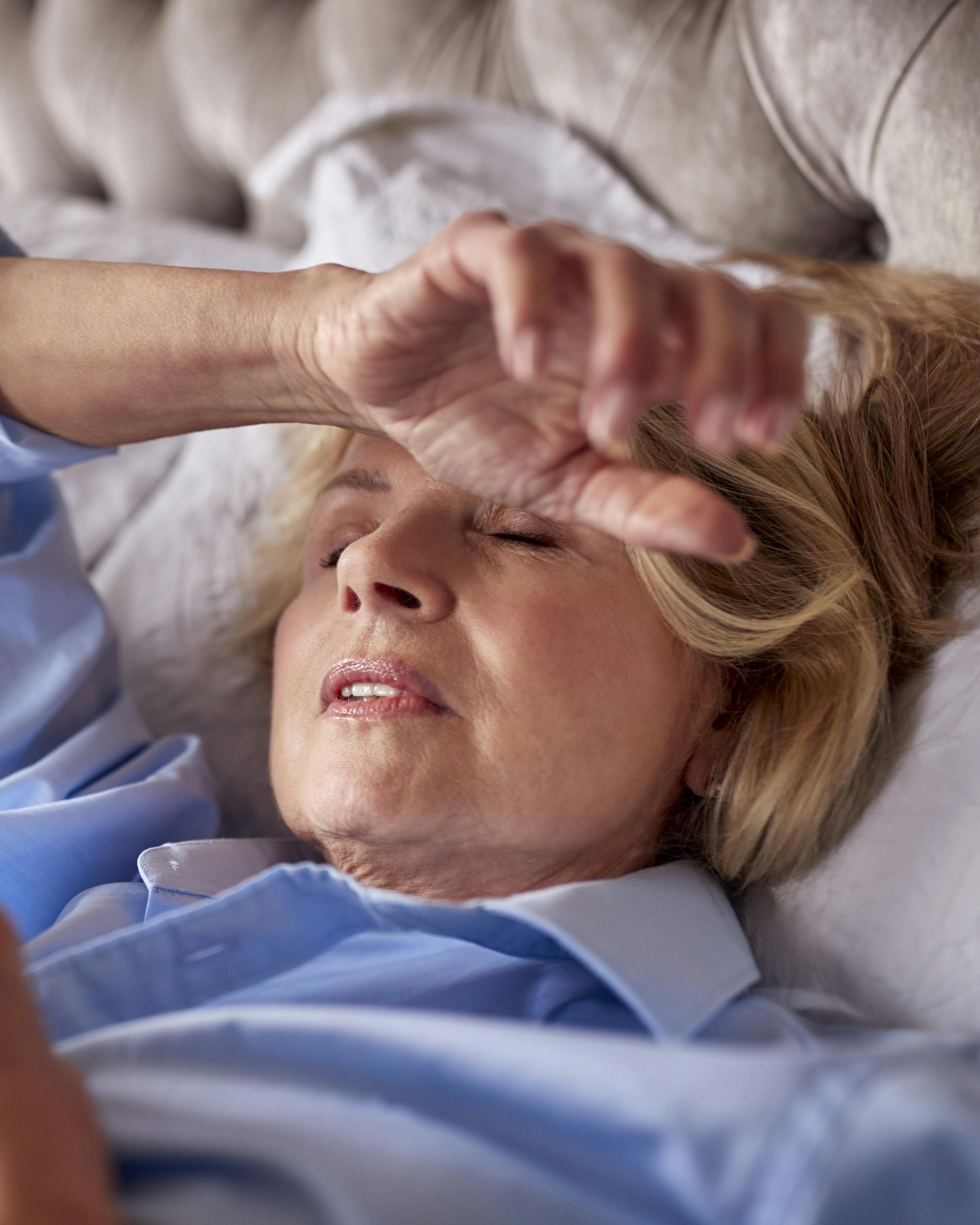 Kvinde i overgangsalderen kæmper med søvnbesvær derhjemme i sin seng