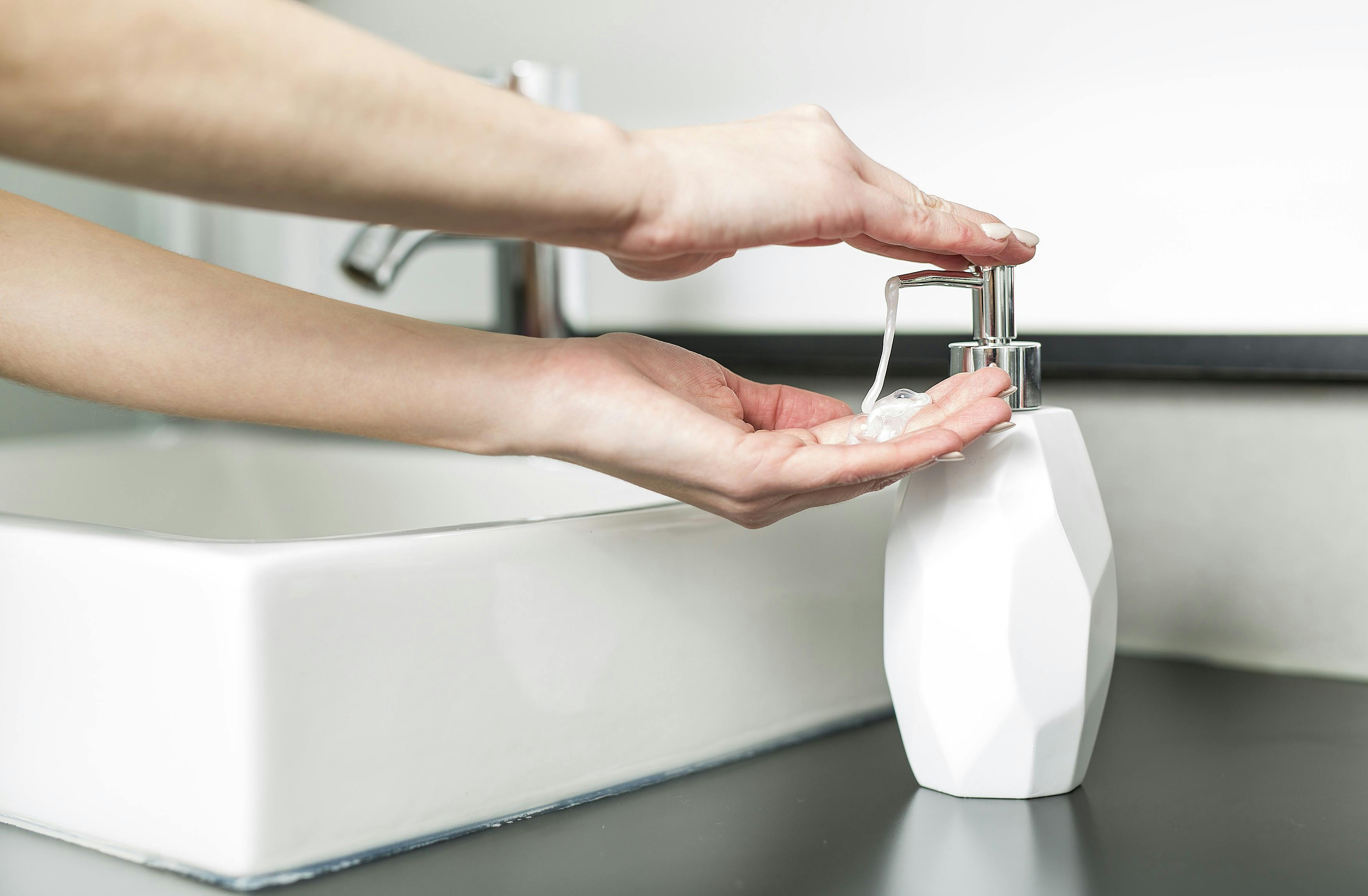 Kvinde tager sæbe fra en dispenser.