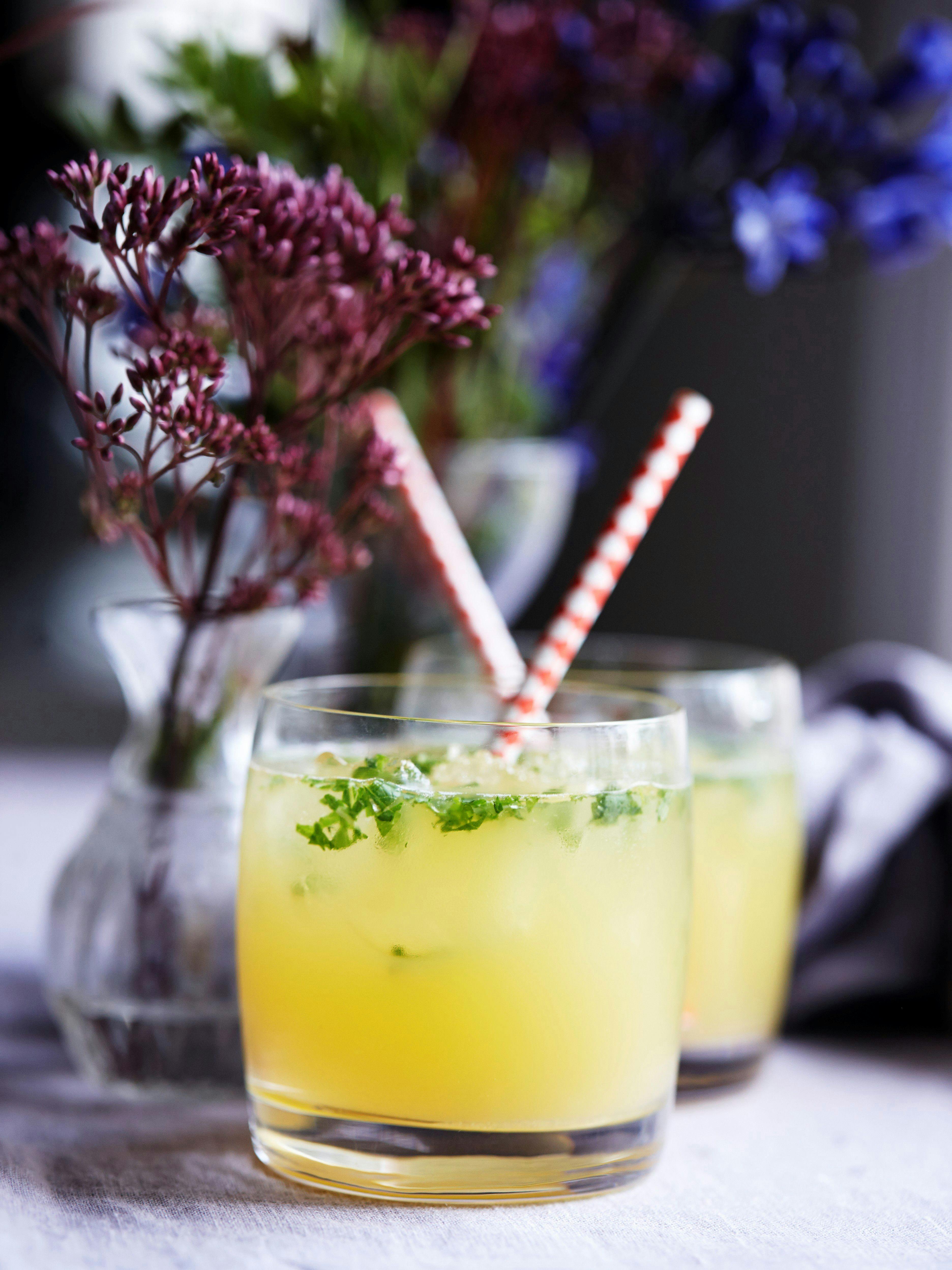 Gul cocktail i glas med sugerør