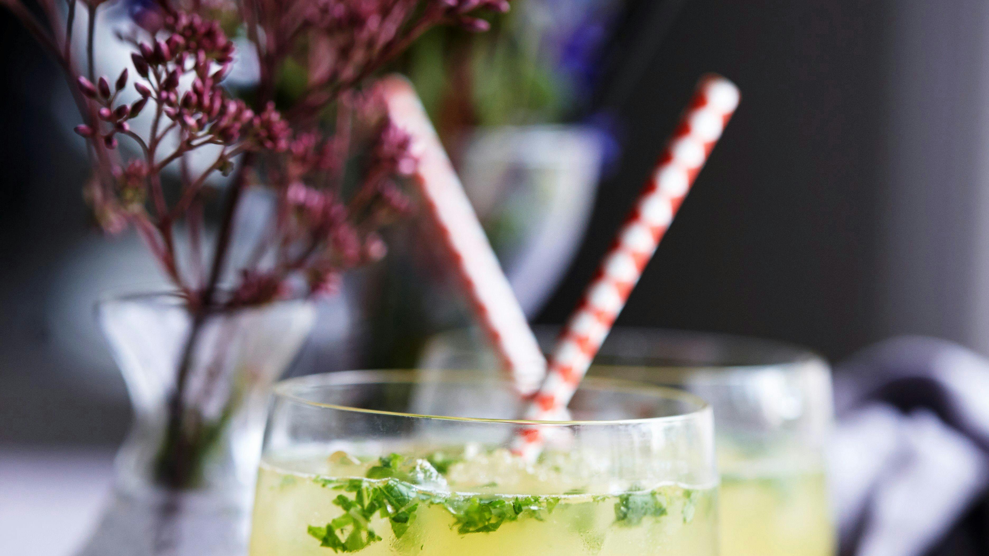 Gul cocktail i glas med sugerør