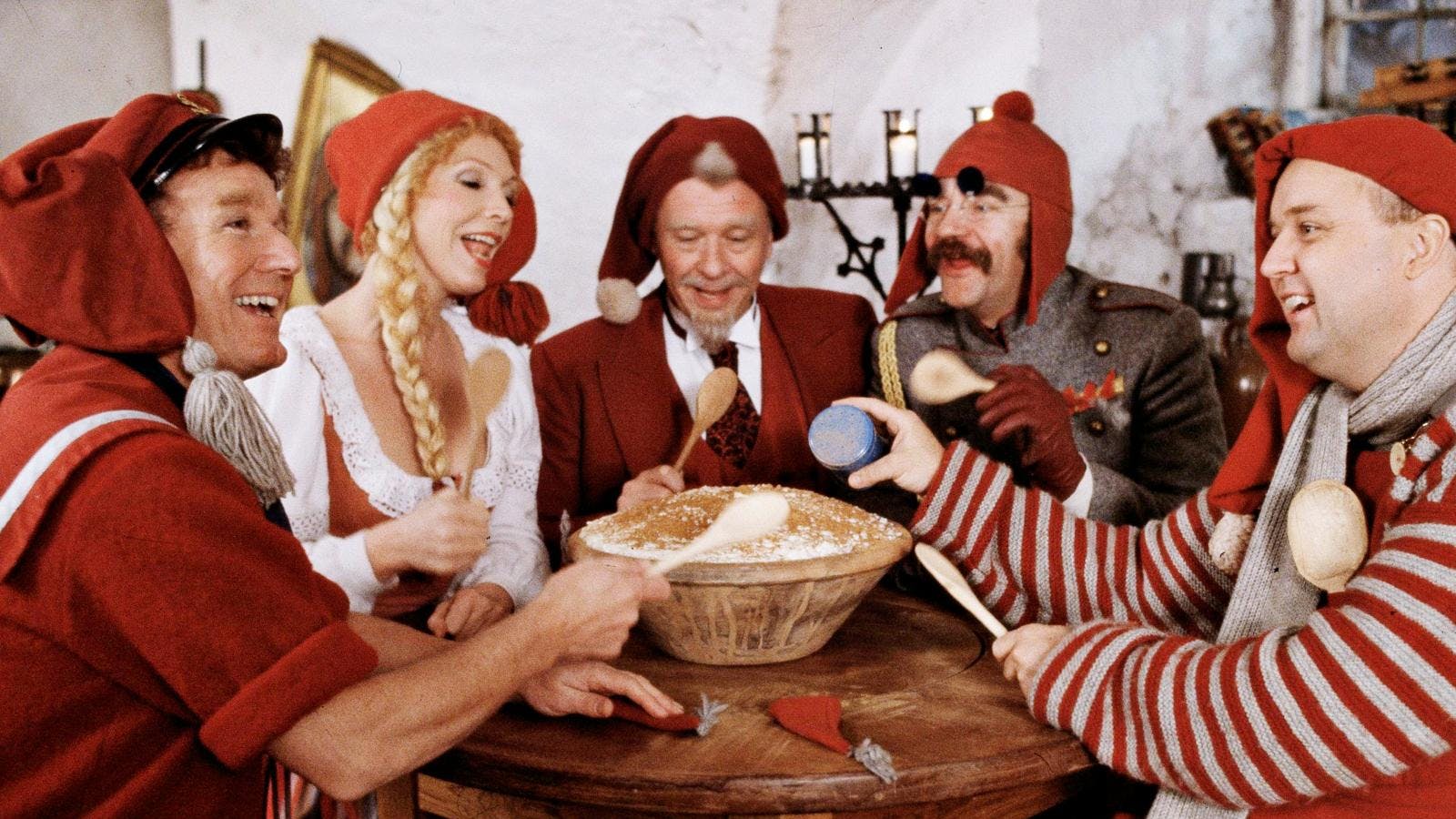 De fem medlemmer af Nissebanden sidder rundt om et bord og spise risengrød