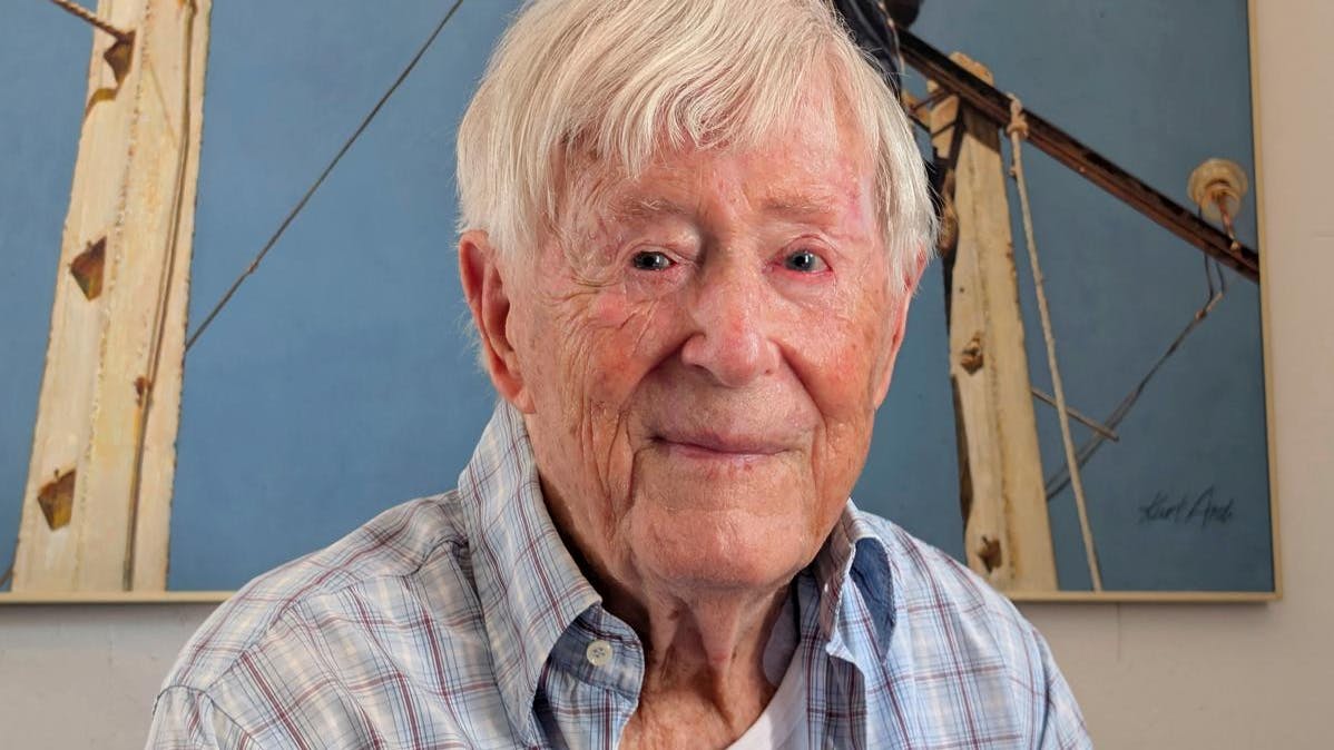 Kurt Ard sidder foran et maleri, han har malet af fattige landarbejdere i Andalusien