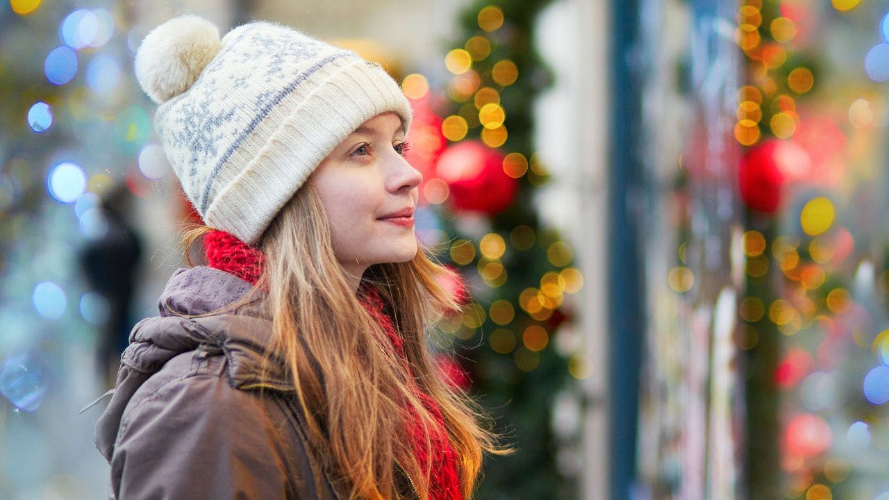 Teenagepige kigger på butiksvindue med juleudsmykning