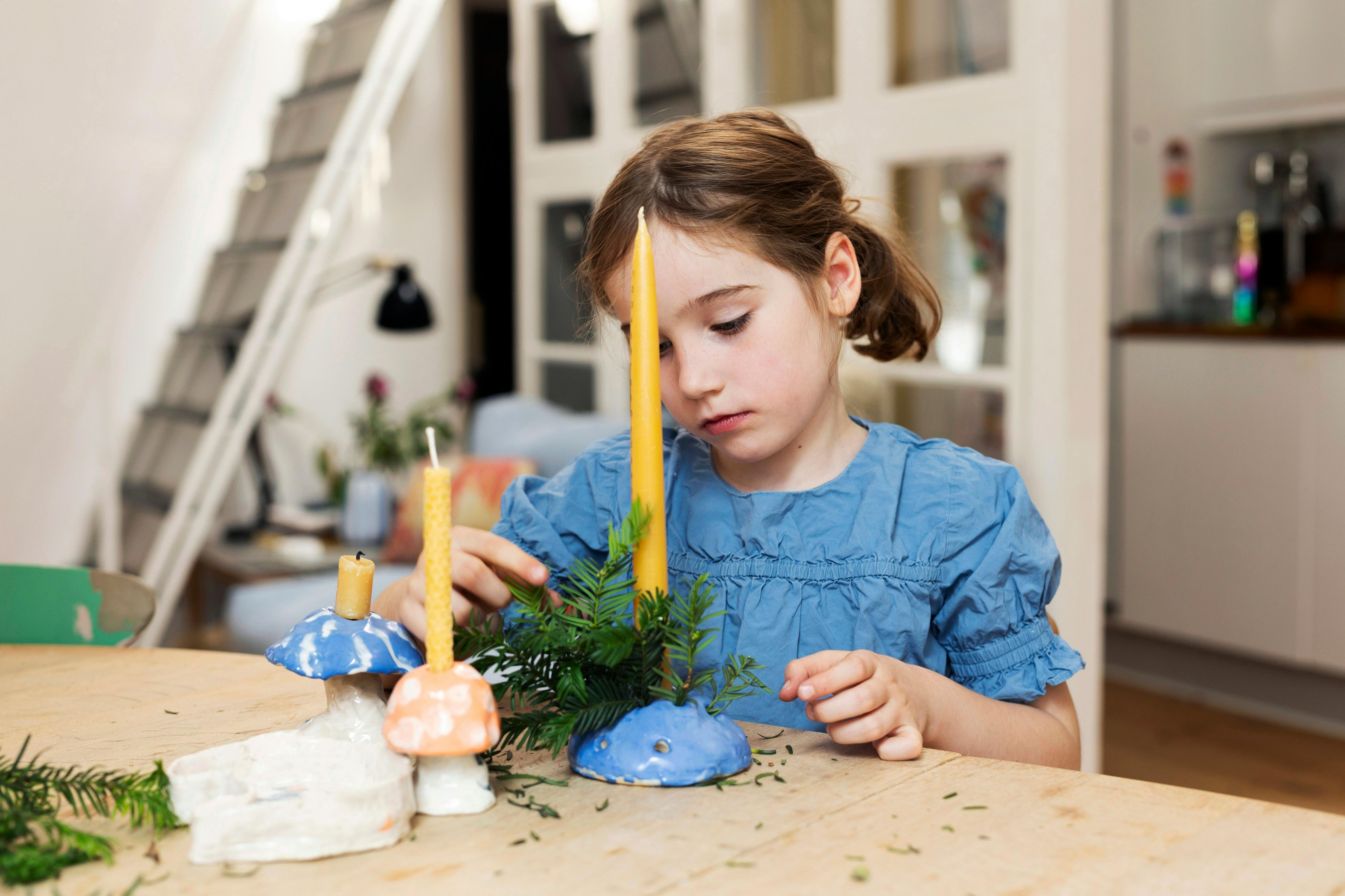 Pige sidder med lysestage