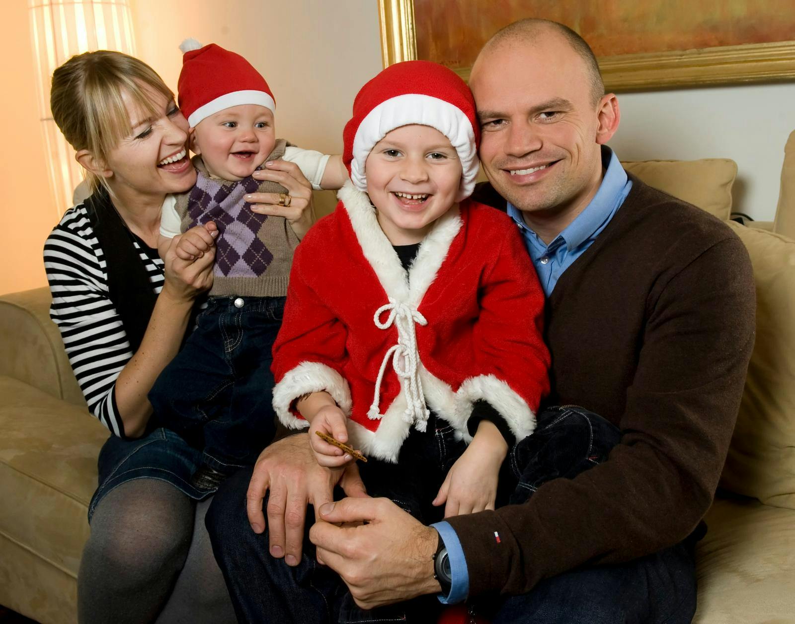 Jesper Vollmer og Annette Heick i en sofa med deres to børn, der har nissetøj og nissehuer på
