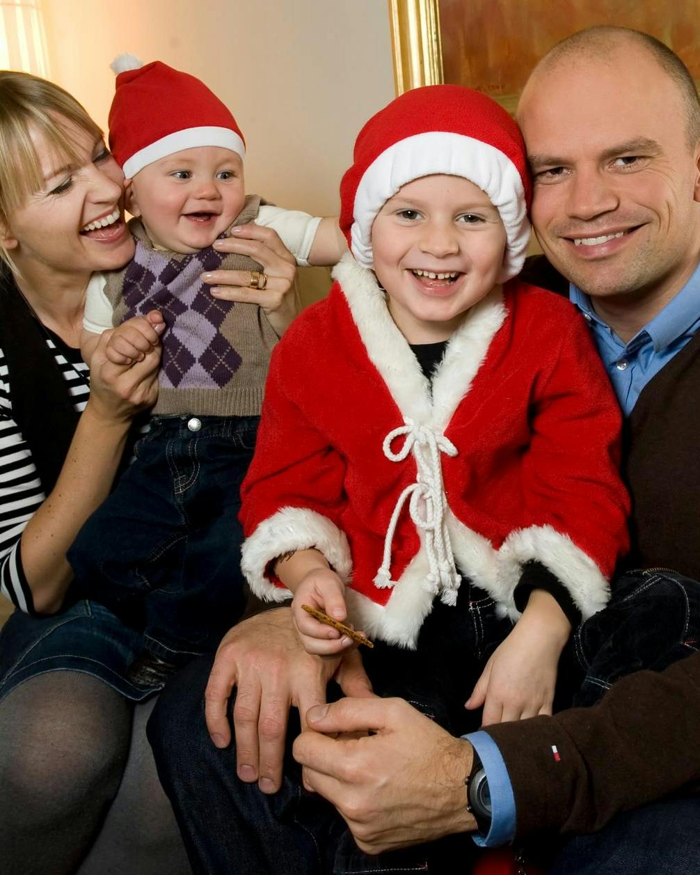 Jesper Vollmer og Annette Heick i en sofa med deres to børn, der har nissetøj og nissehuer på