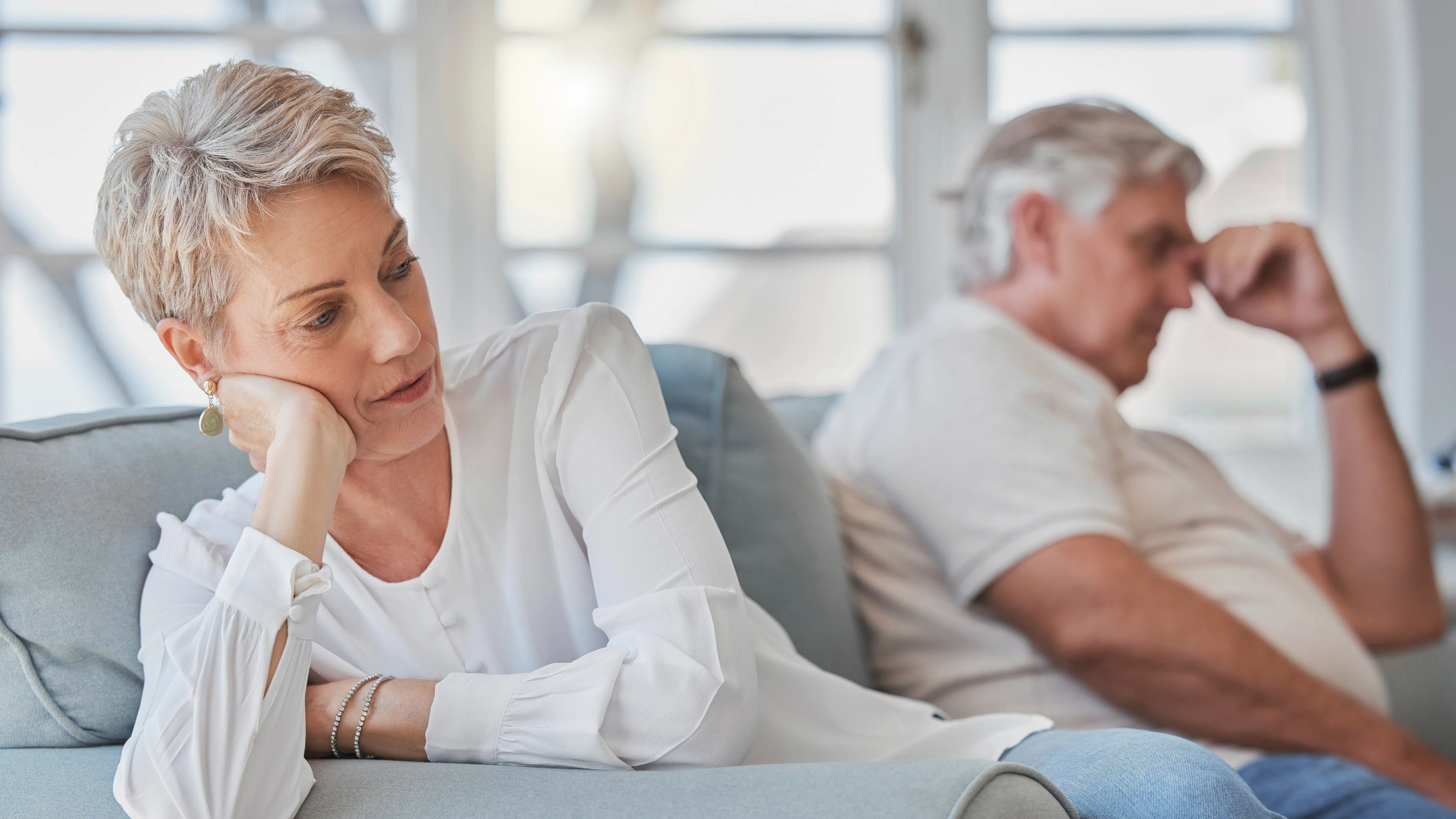 Par, der sidder sure i hver sin ende af sofaen