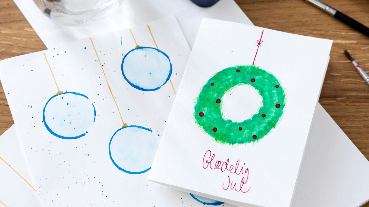 Julekort med malet julekort og julekugler