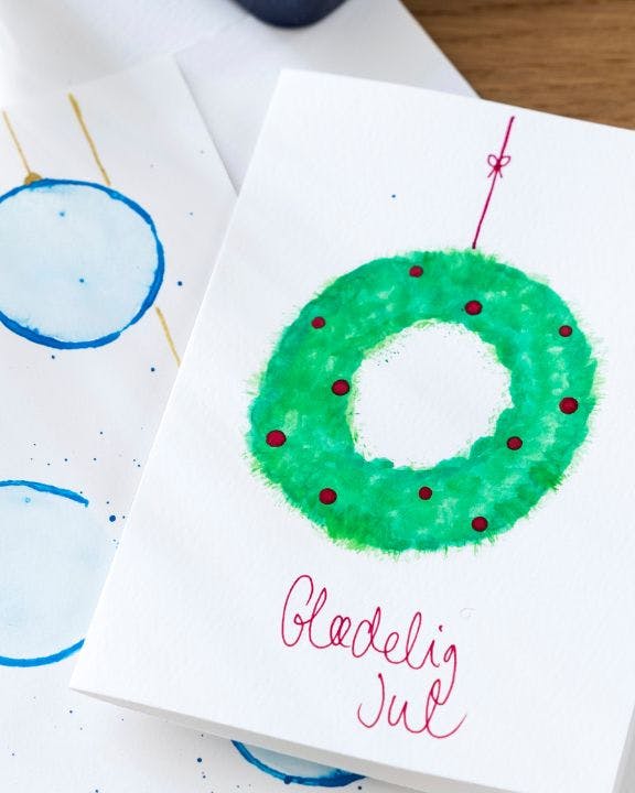Julekort med malet julekort og julekugler