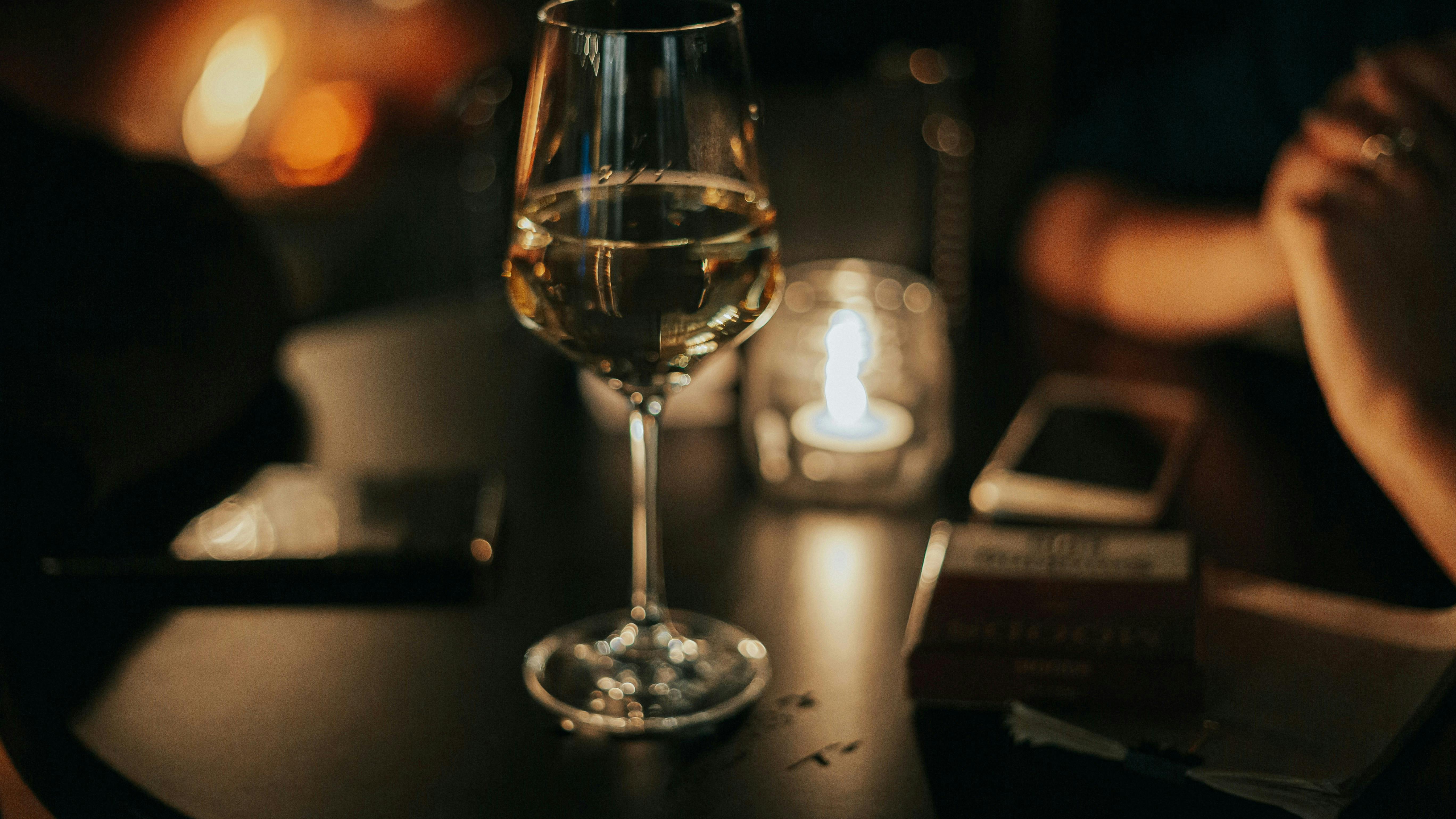 Et fyldt hvidvinsglas på et bord