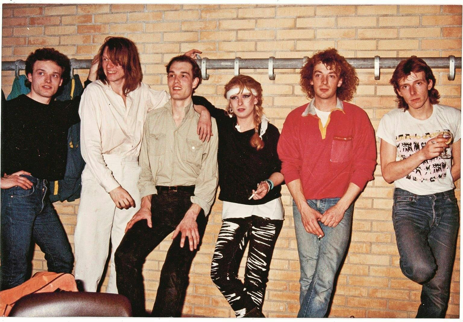 Bandet Sneakers står op ad en væg.