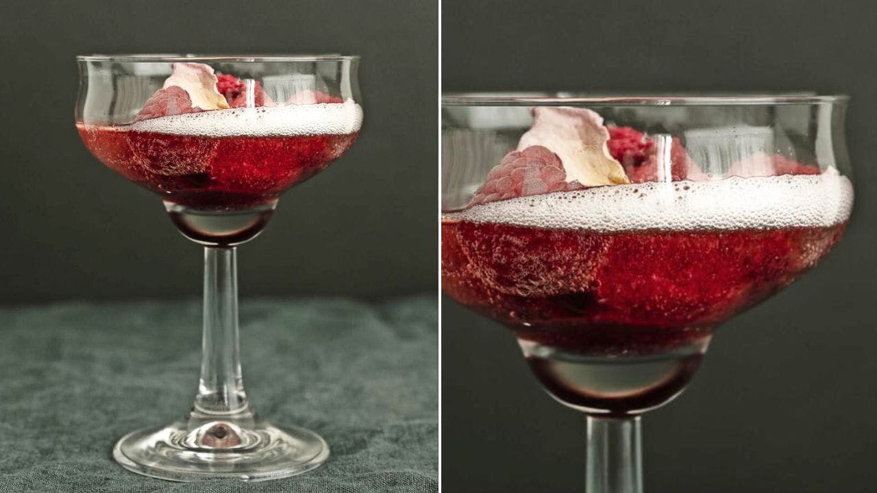 Rød cocktail i glas med hindbær