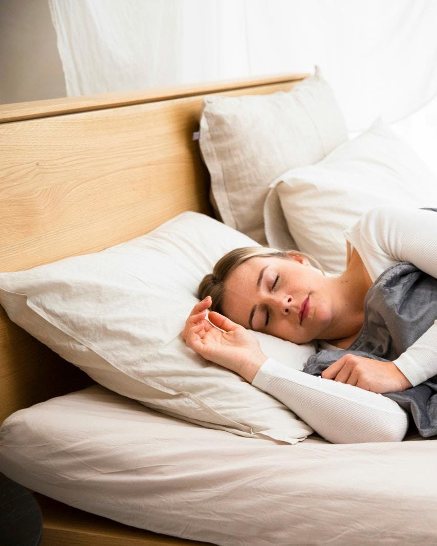 En kvinde, der ligger i en seng og sover