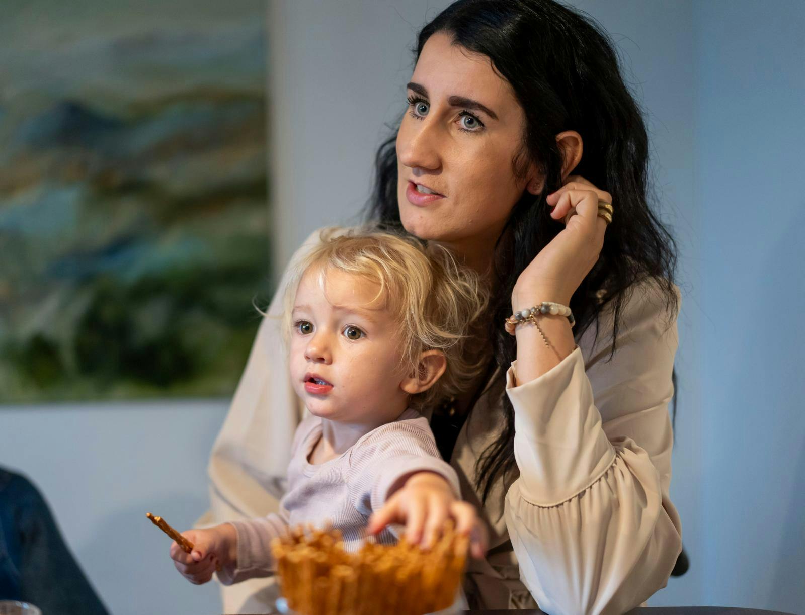 En kvinde med en lille pige på skødet.