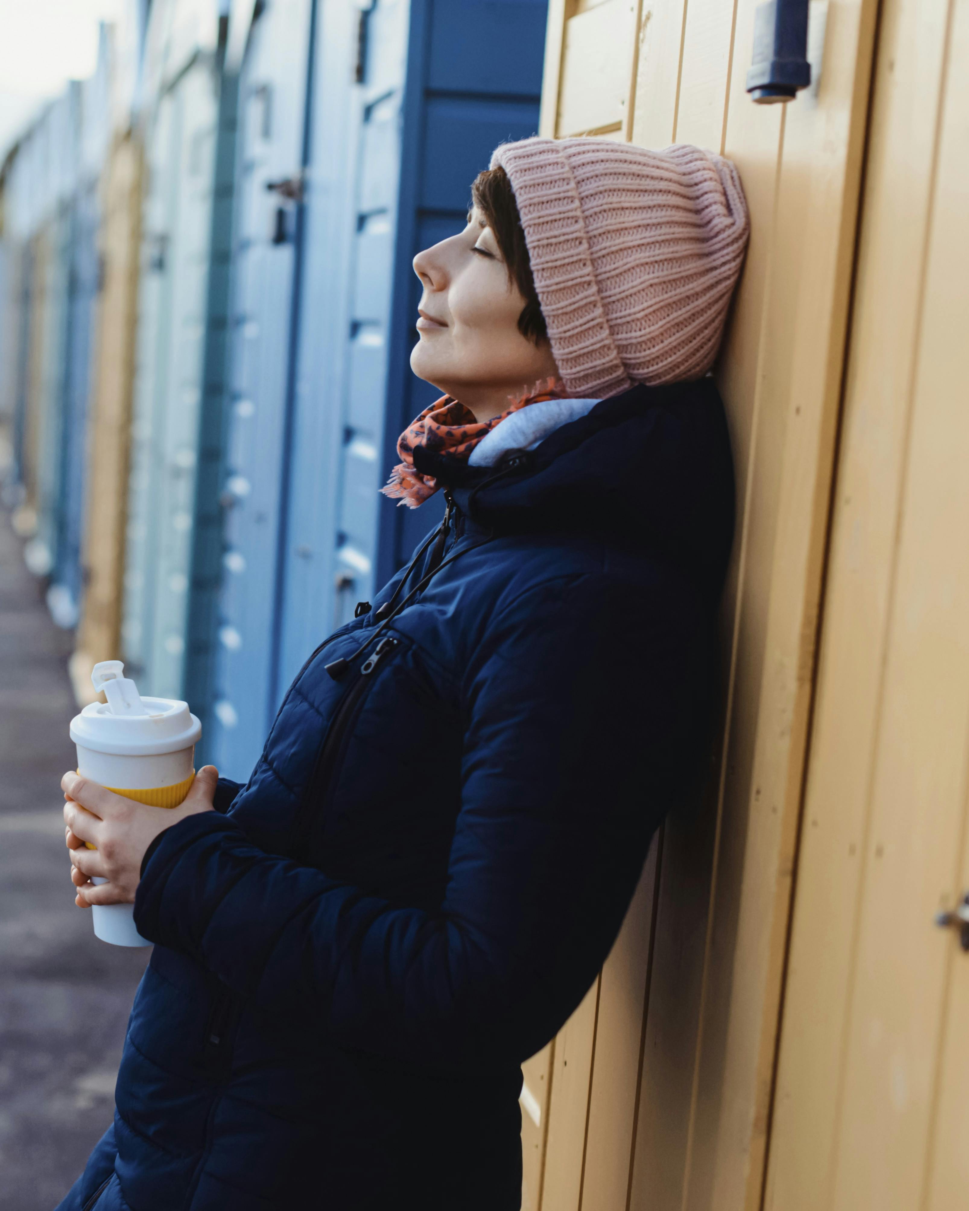 Smilende og afslappet kvinde med kaffekop i hånden