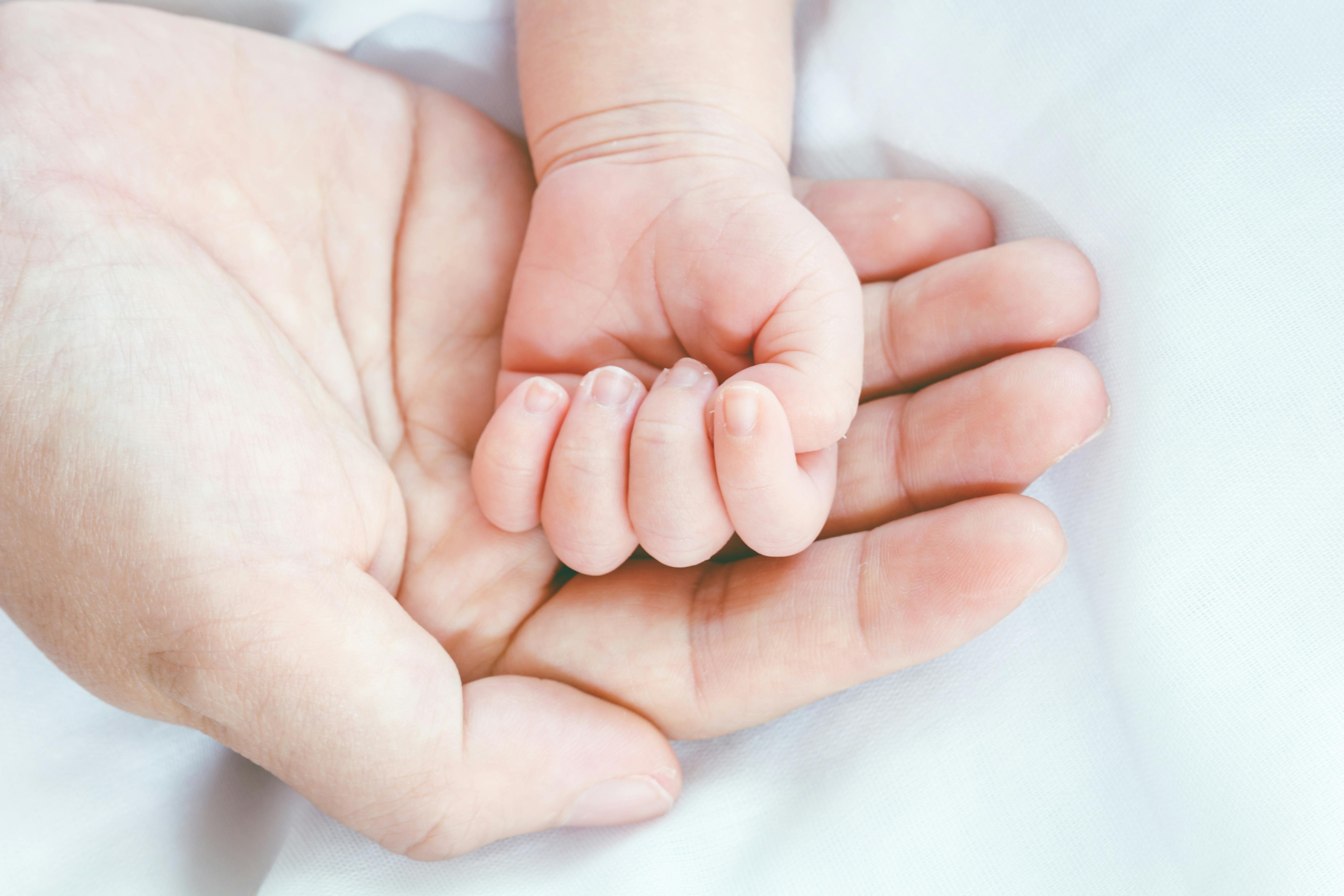 Nyfødts hånd i sin mors
